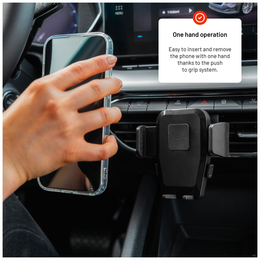 Eine Hand legt ein Telefon in eine schwarze Autohalterung, die am Lüftungsschlitz befestigt ist.
