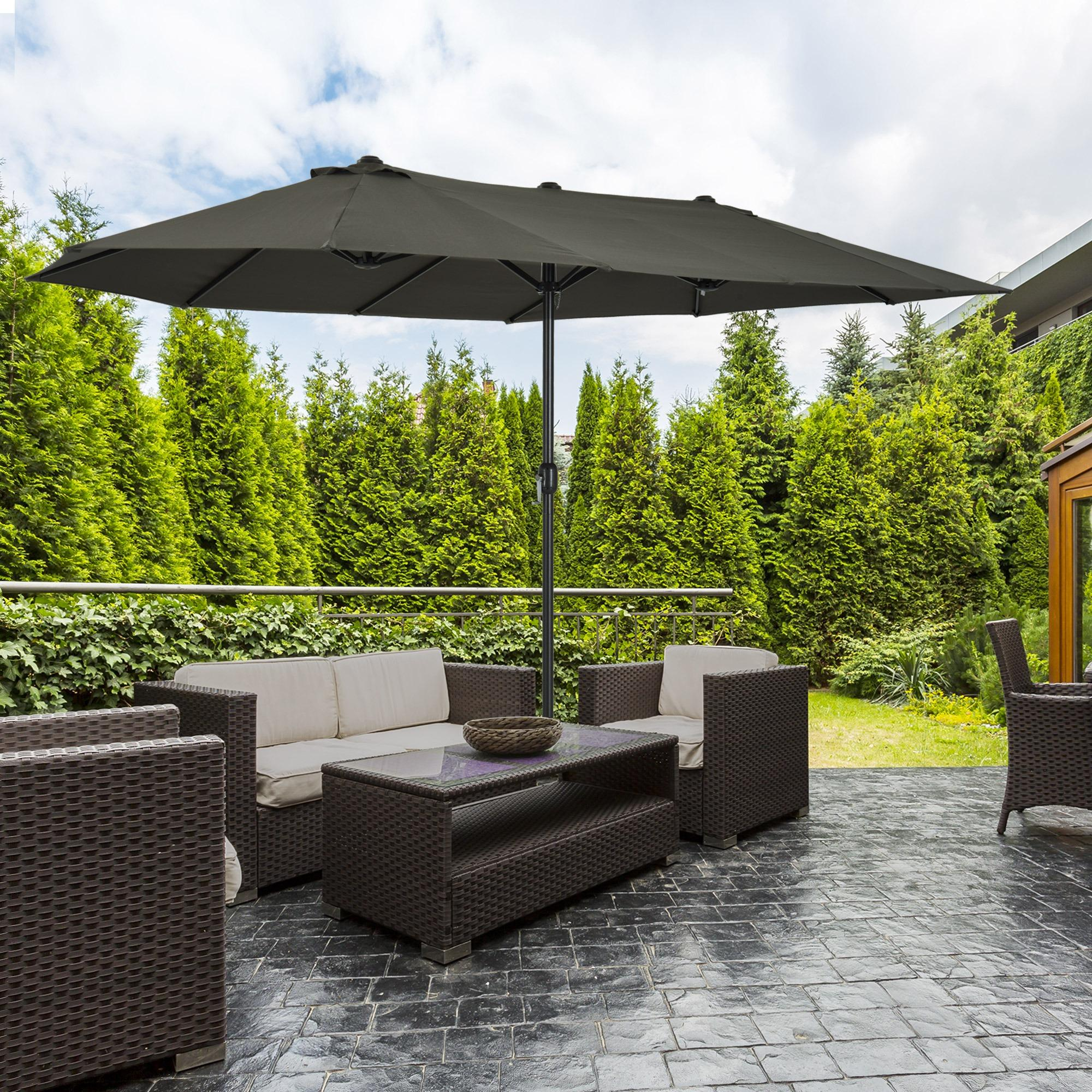 Outdoor-Terrassengarnitur mit großem dunkelgrauem Sonnenschirm, Sofas, Stühlen und Tisch.