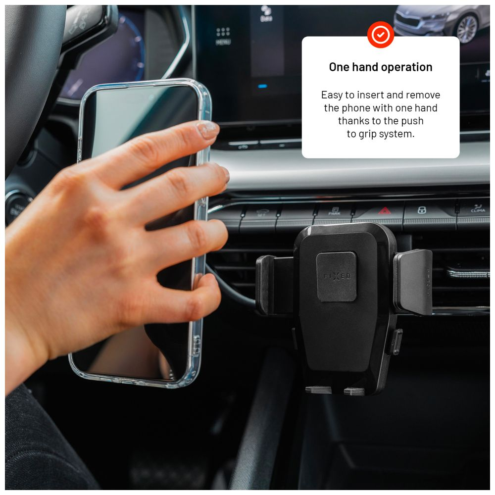 Ein schwarzer Telefonhalter ist in einem Auto montiert, mit einer Hand, die ein Telefon daneben hält.