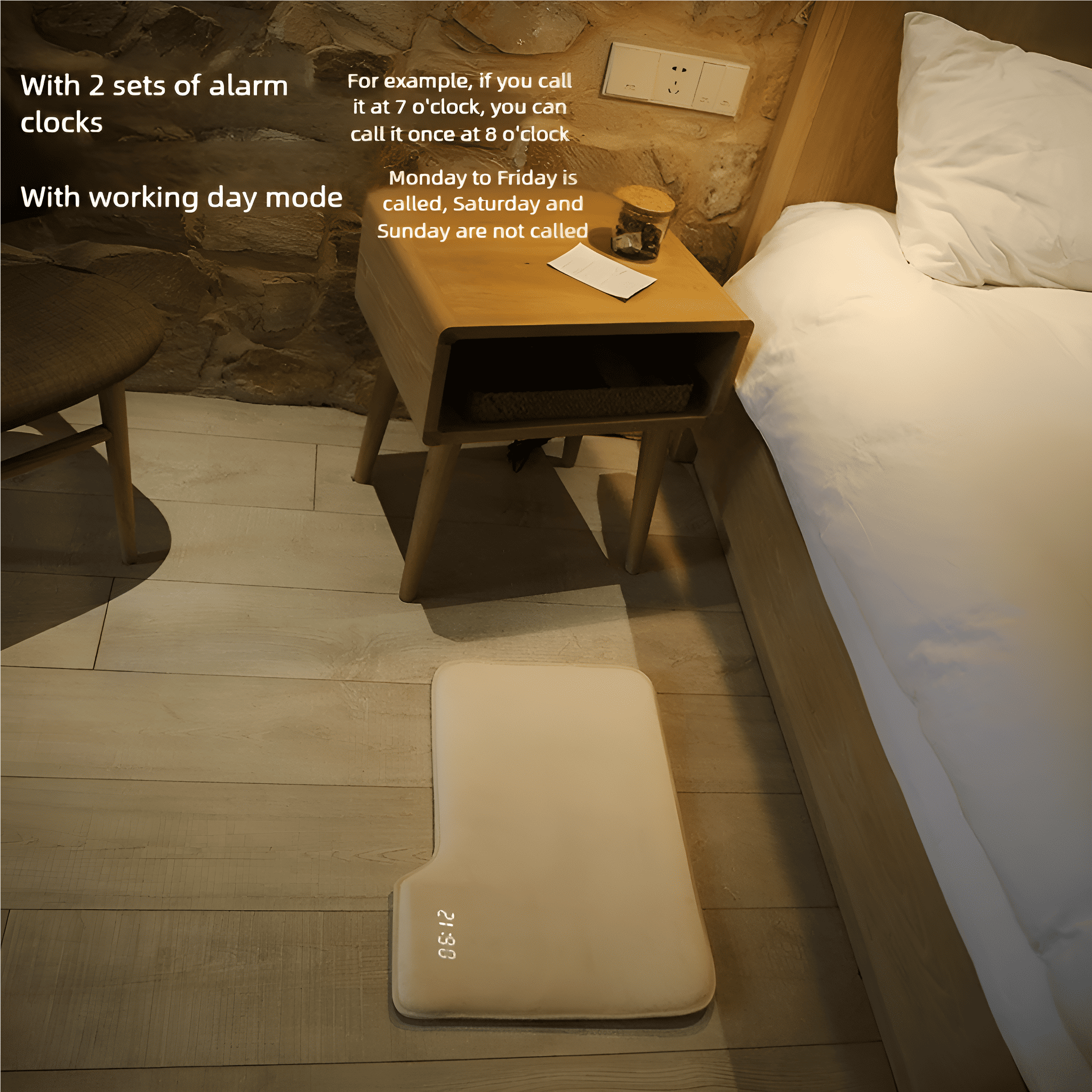 Eine weiße Smart-Clock-Matte liegt auf einem Holzboden neben einem Bett und einem Nachttisch.