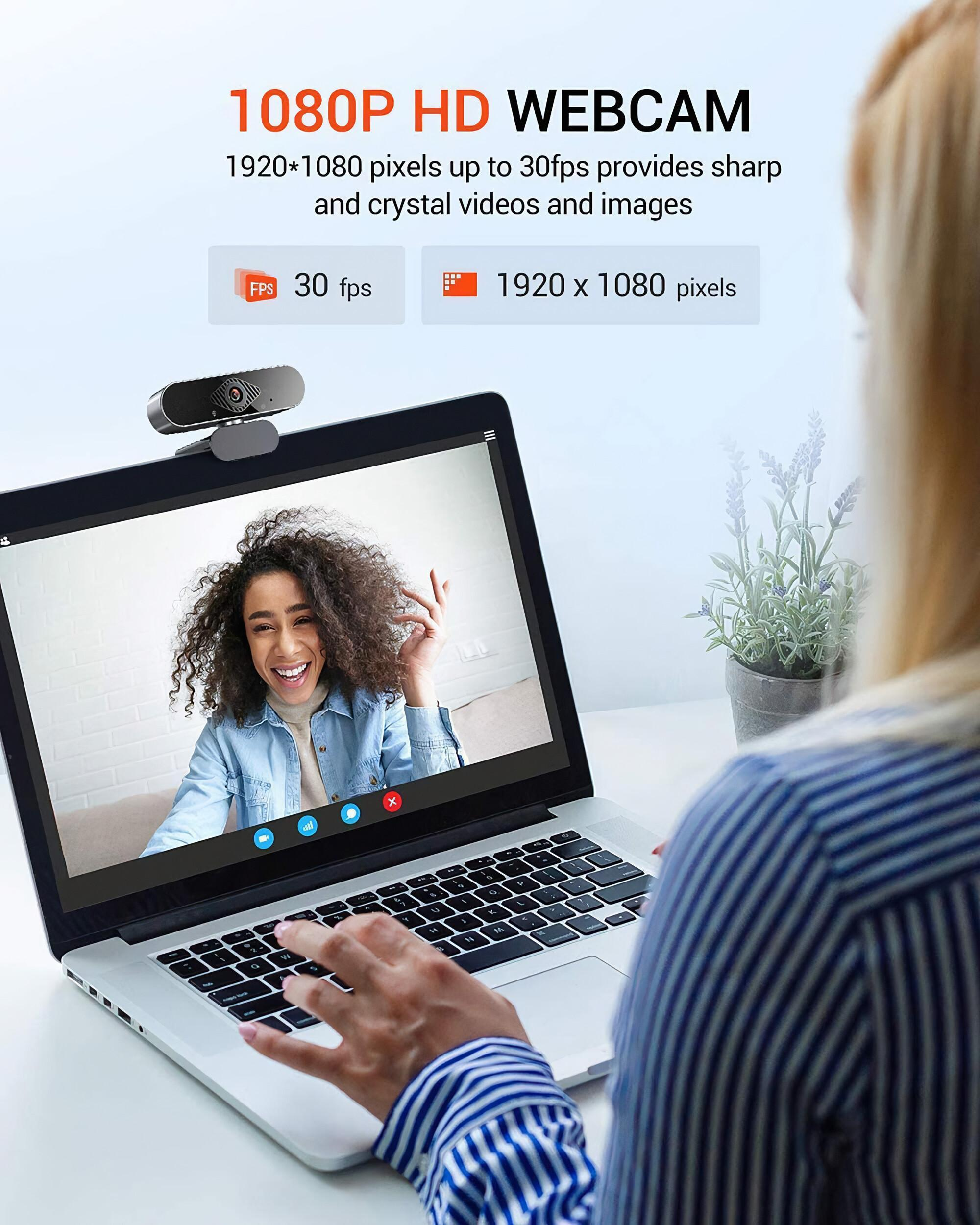 Eine Frau benutzt einen Laptop mit einer Webcam oben. Der Bildschirm zeigt einen Videoanruf mit einer lächelnden Frau.