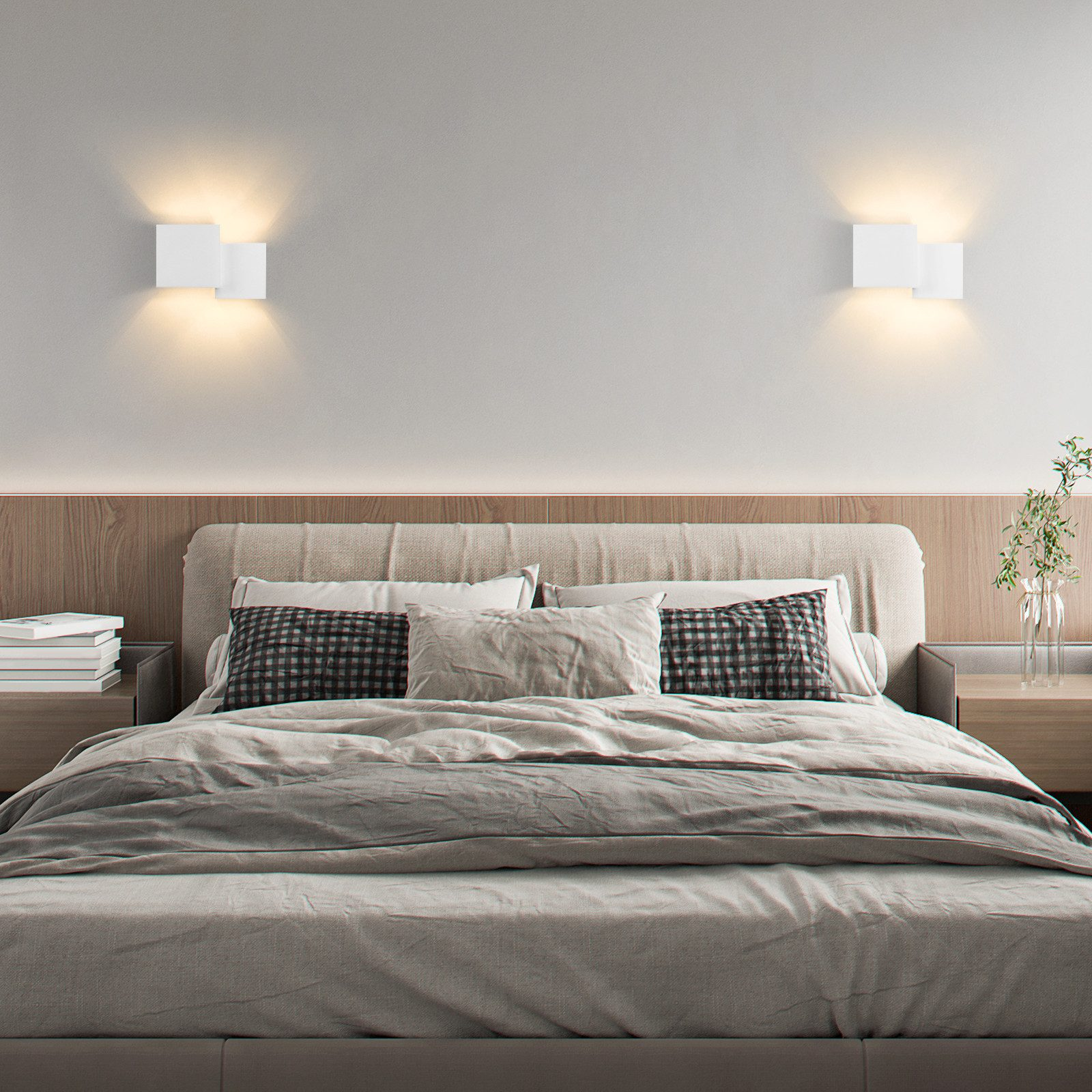 Camera da letto con letto, due luci a parete quadrate, due comodini e una palette di colori neutri.
