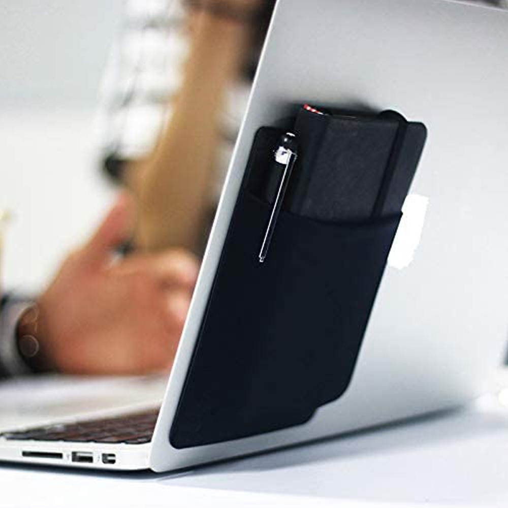Eine schwarze Tasche ist an einem weißen Laptop befestigt. Ein Stift und ein Notizbuch befinden sich in der Tasche. Eine Person benutzt den Laptop.