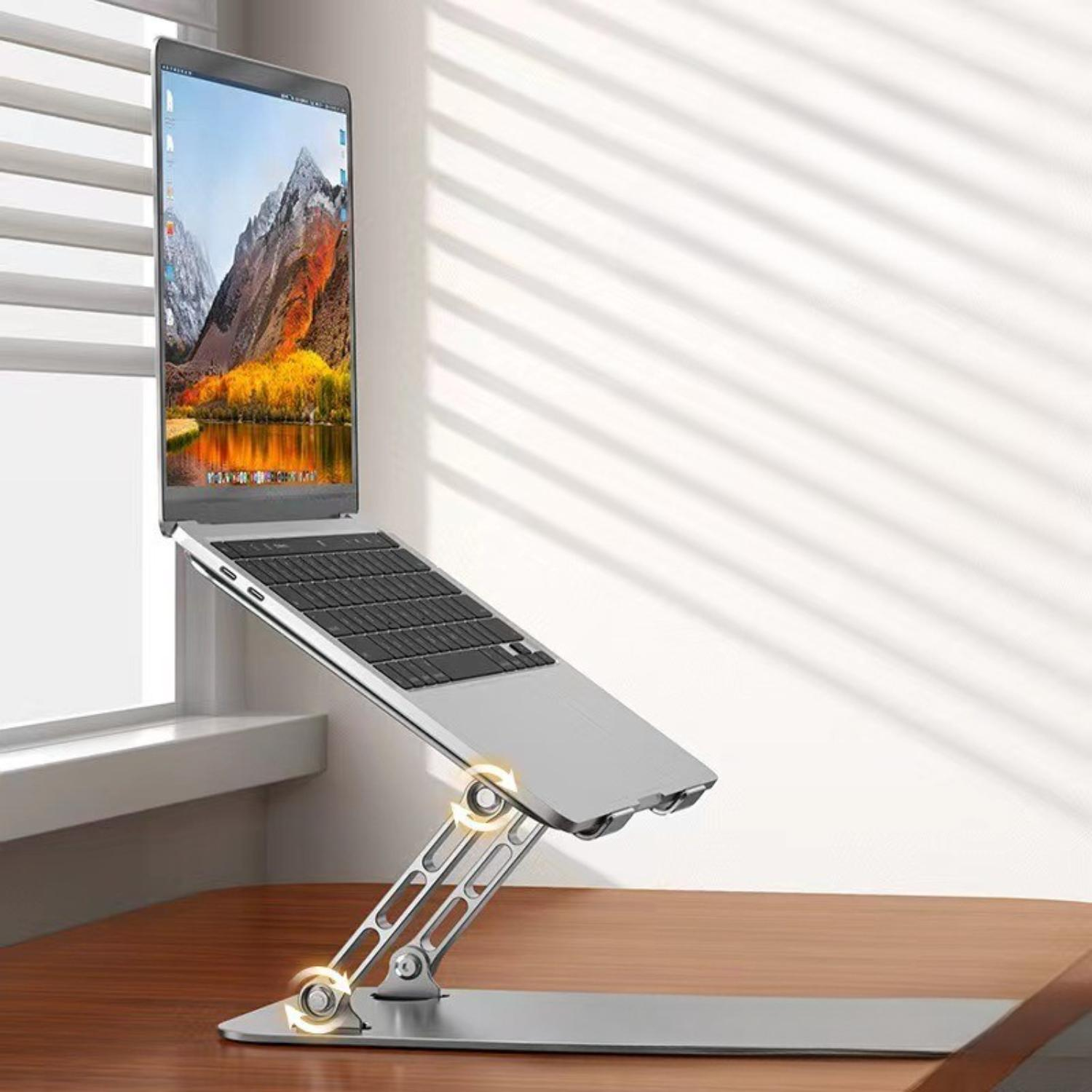 Silberner Laptop auf einem Ständer am Fenster, mit einer Naturlandschaft auf dem Bildschirm, auf einem Holztisch.