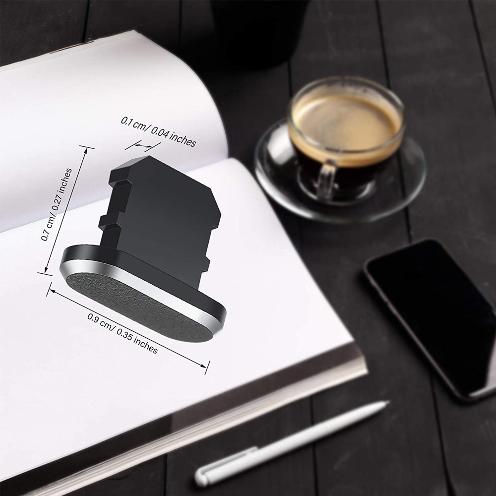 Datenportabdeckung neben einer Tasse Kaffee und einem Telefon, mit auf einer weißen Buchseite beschrifteten Abmessungen auf einem dunklen Tisch.