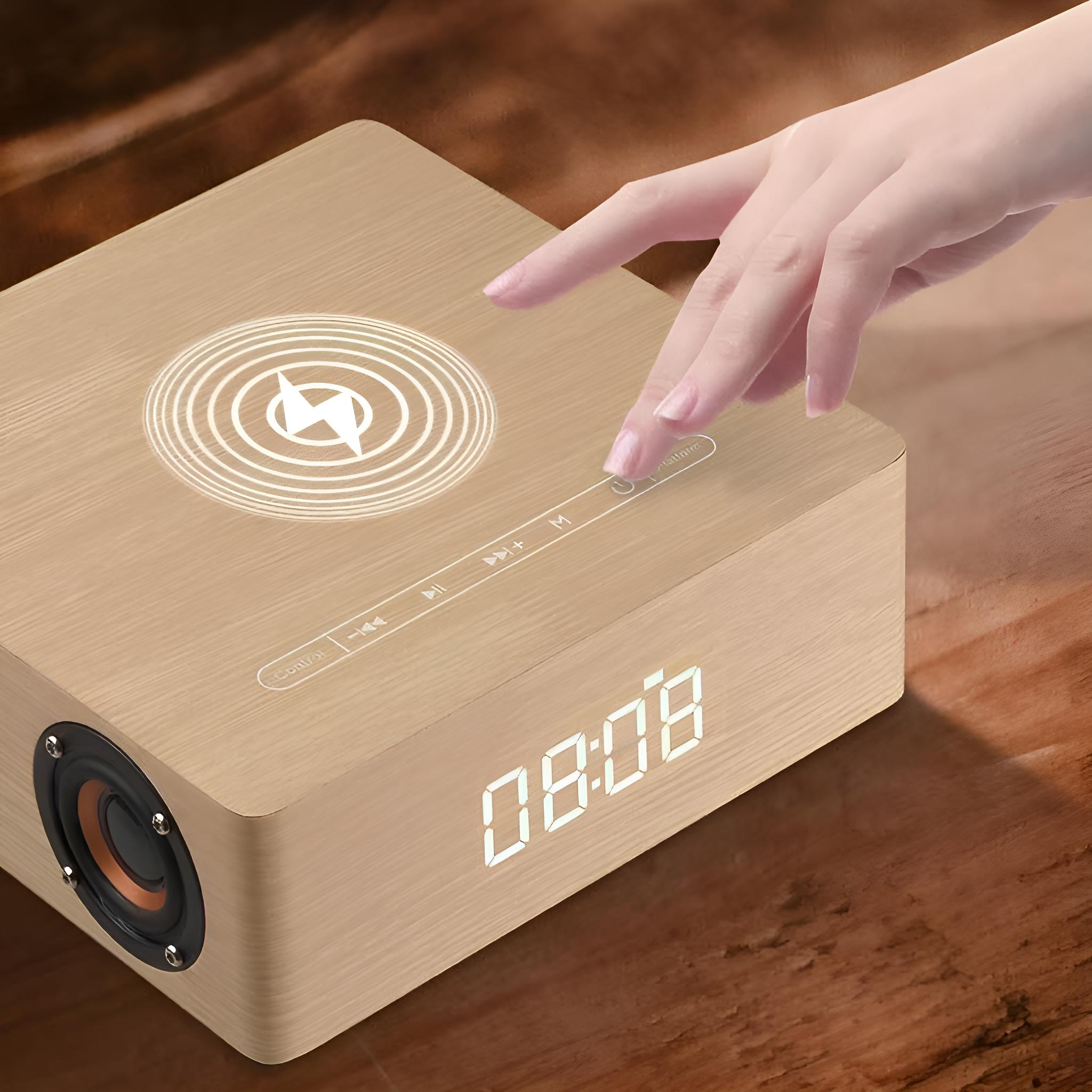 Eine Person berührt den Netzschalter eines hölzernen Bluetooth-Lautsprechers mit einer Digitaluhr.