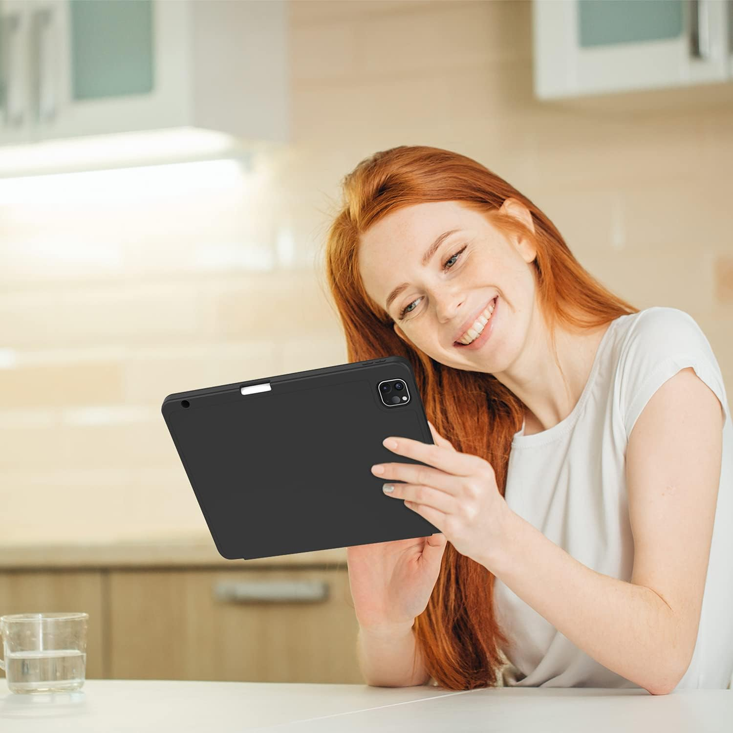Eine Frau betrachtet ein iPad und lächelt. Sie hält die schwarze Hülle.