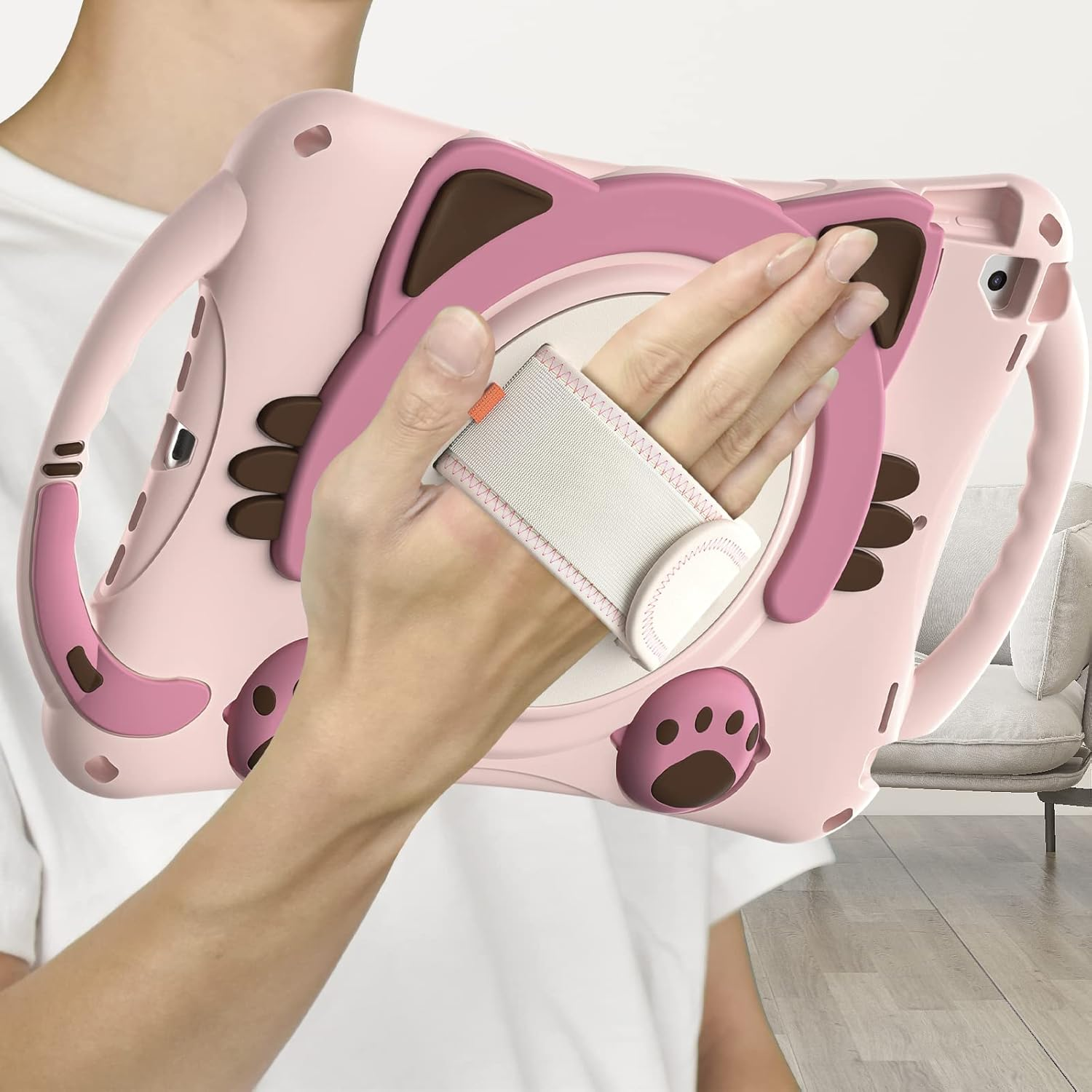 Eine Hand, die ein Tablet in einer rosa Katzenhülle hält und den Handriemen zeigt.