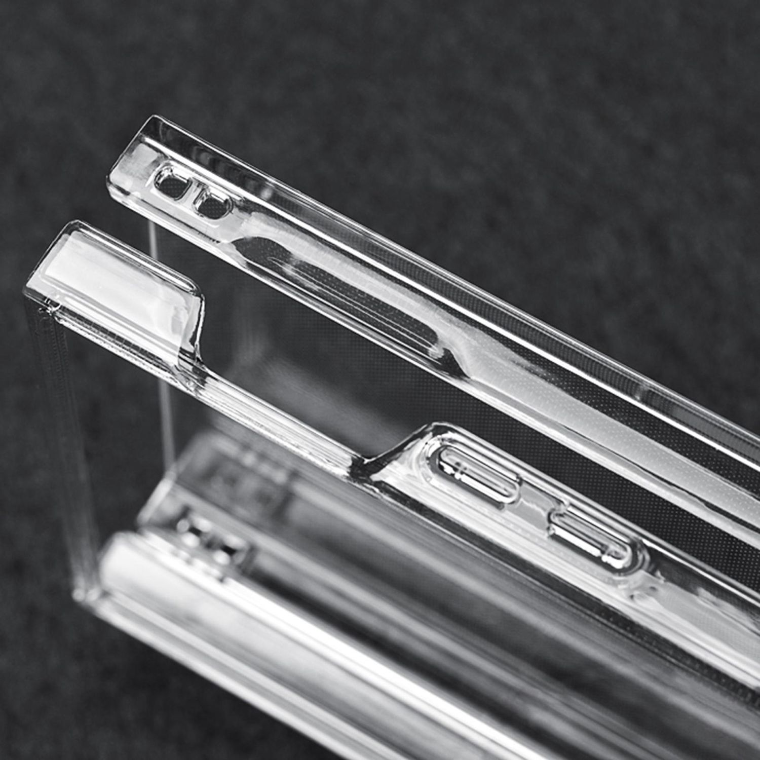 Primer plano de la esquina de una funda de teléfono transparente, que muestra recortes precisos de botones y material transparente.