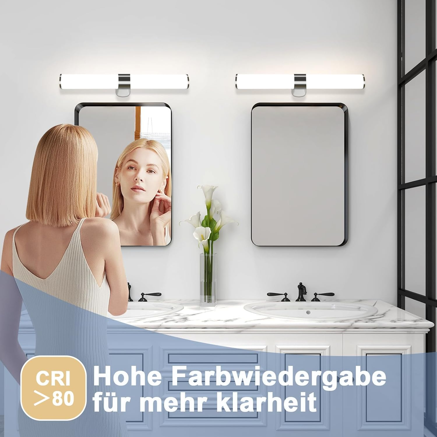 Badezimmerszene mit zwei Spiegeln, Waschtischlampen und einer Frau, die in den Spiegel schaut.