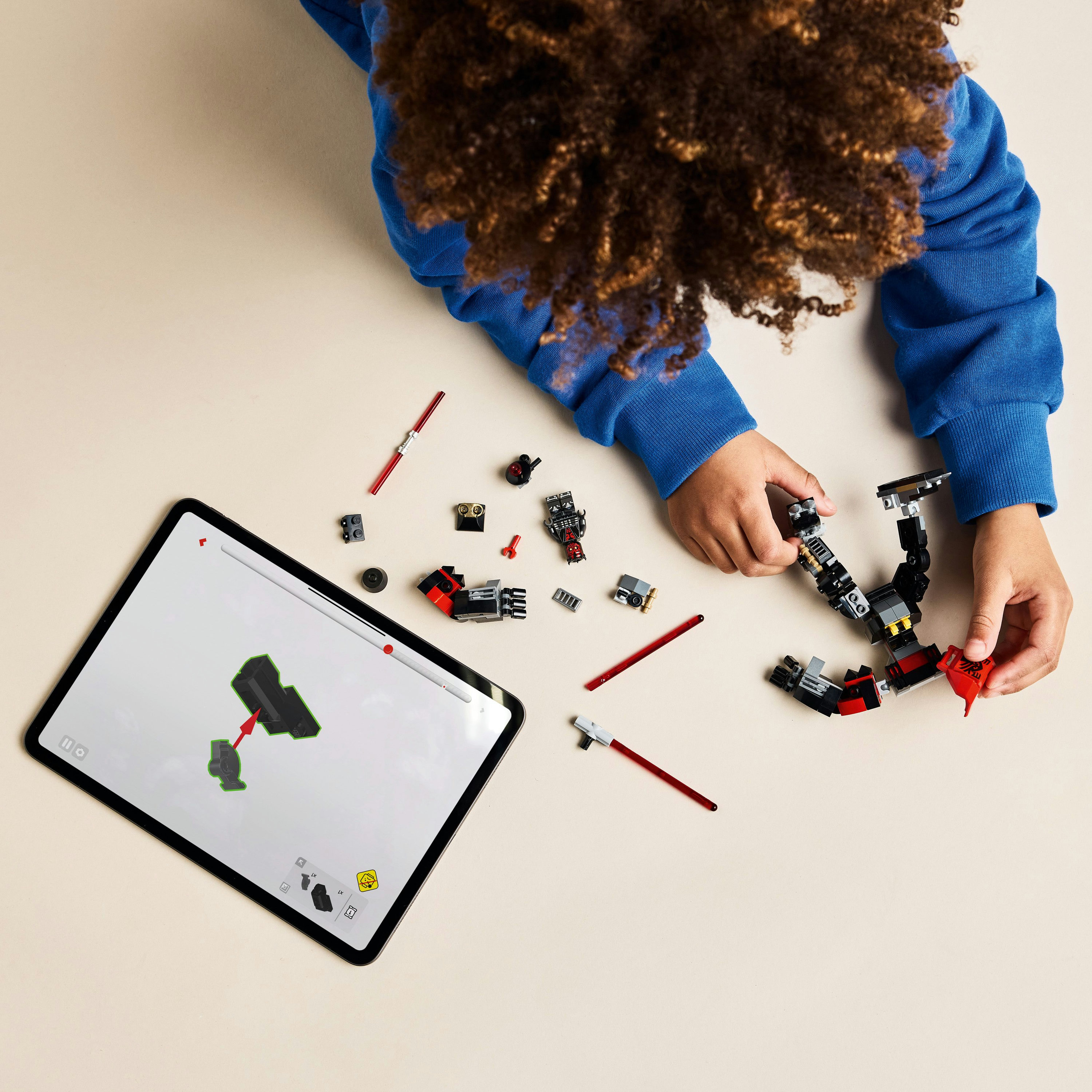 Un bambino costruisce un LEGO Darth Maul Mech con un tablet che mostra le istruzioni.