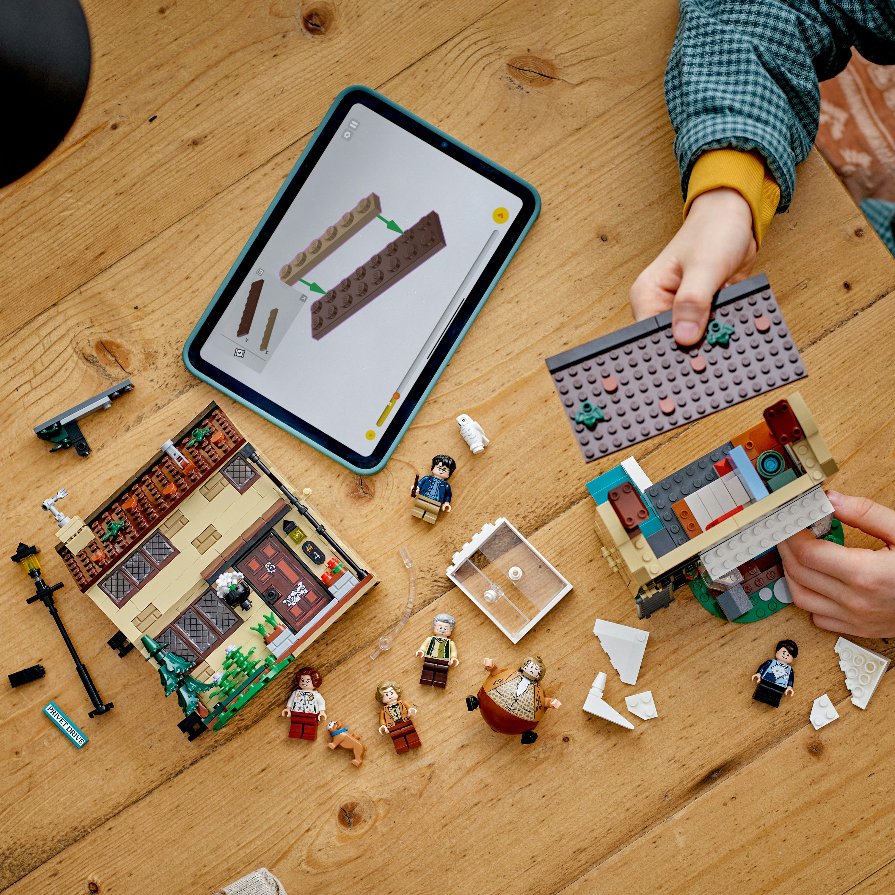 Dziecko składa zestaw LEGO Harry Potter 76451 na drewnianym stole.