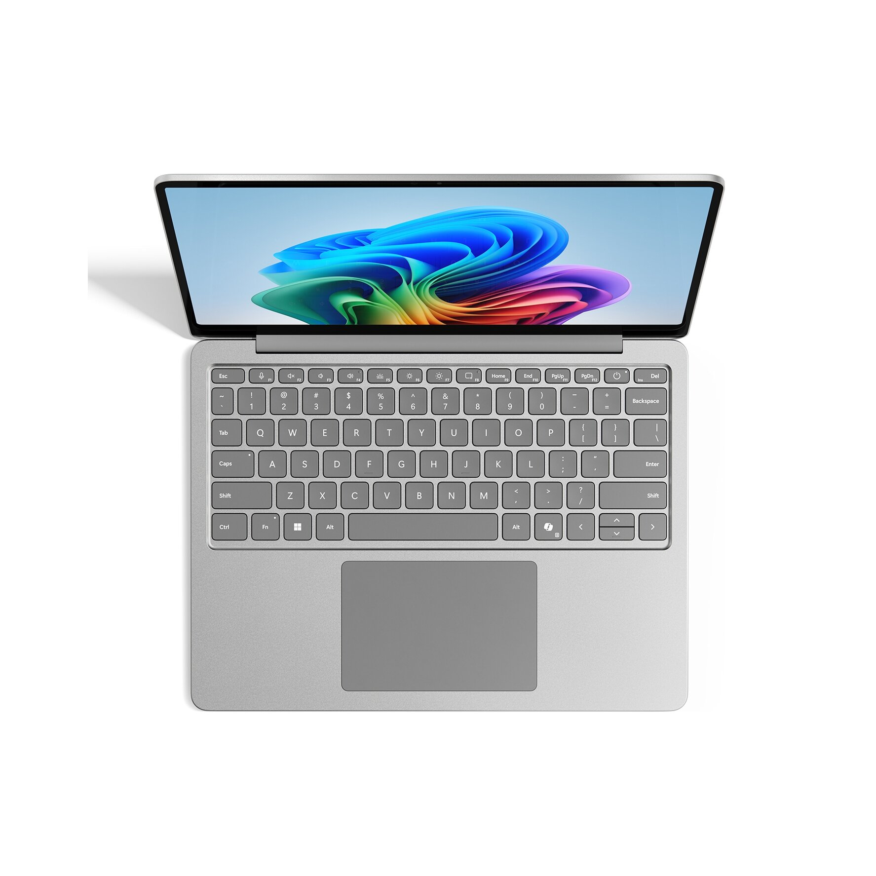 Laptop con cornice argentata, aperto su un tavolo. La tastiera e il touchpad sono visibili. Schermo acceso.