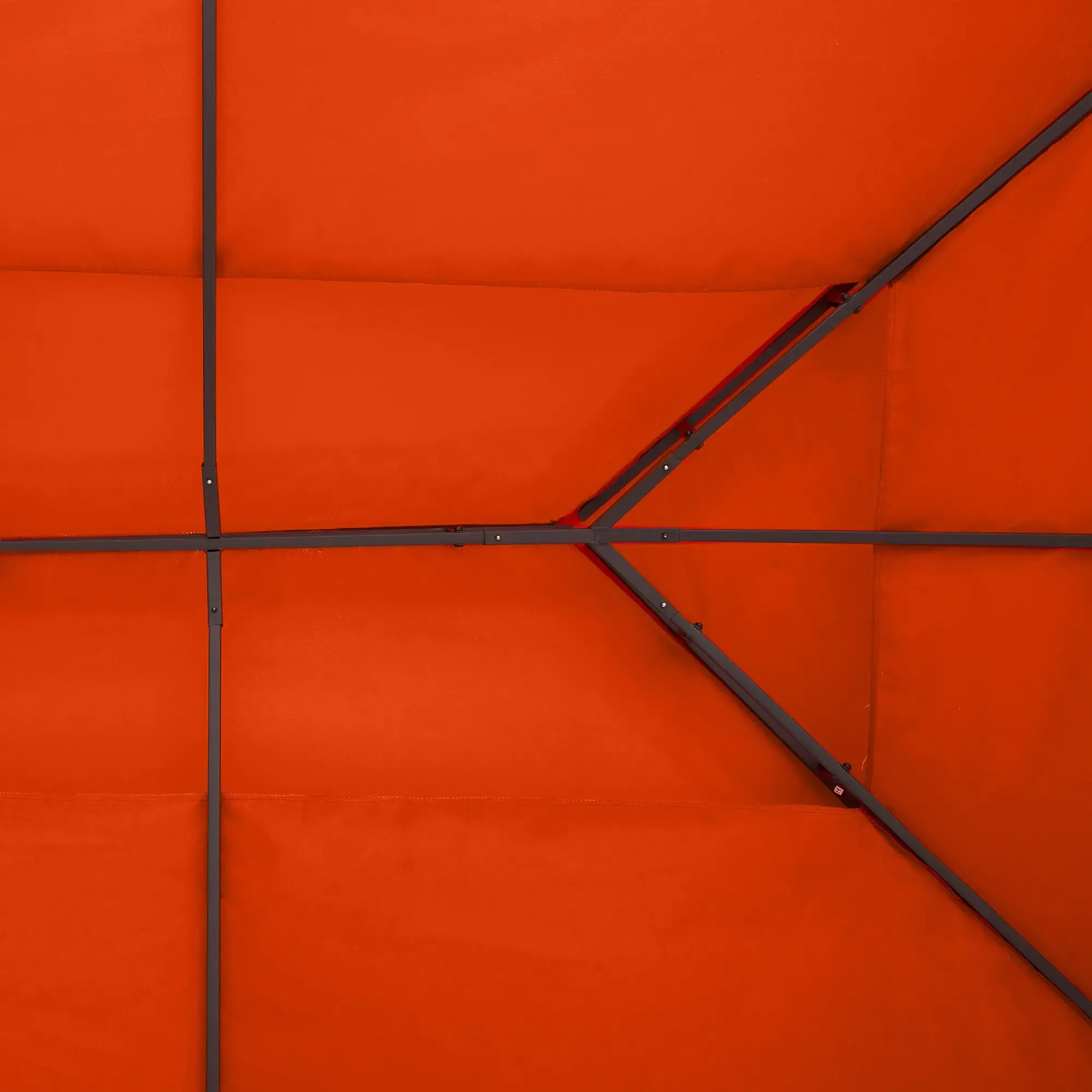 Eine Draufsicht auf die Metallrahmenstruktur des orangefarbenen Gazebodachs, die sein geometrisches Muster zeigt.