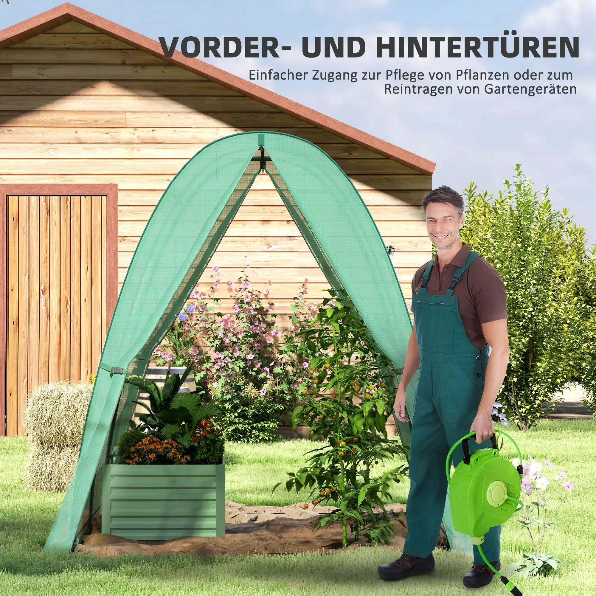 Ein grüner Pflanzenschutz steht in einem Garten mit einem lächelnden Mann, der eine Schlauchtrommel hält.