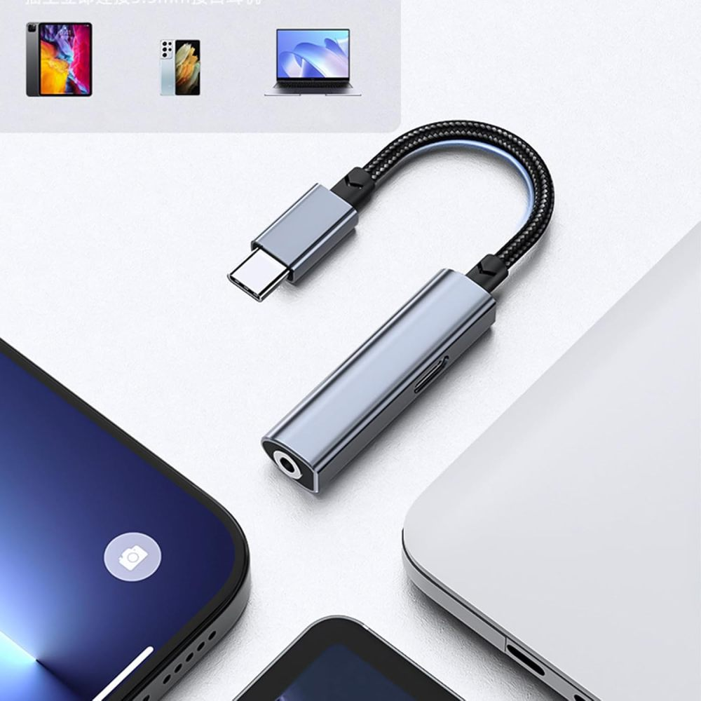 Ein grauer USB-C-auf-Kopfhöreranschluss-Adapter wird mit Telefonen und einem Laptop gezeigt.