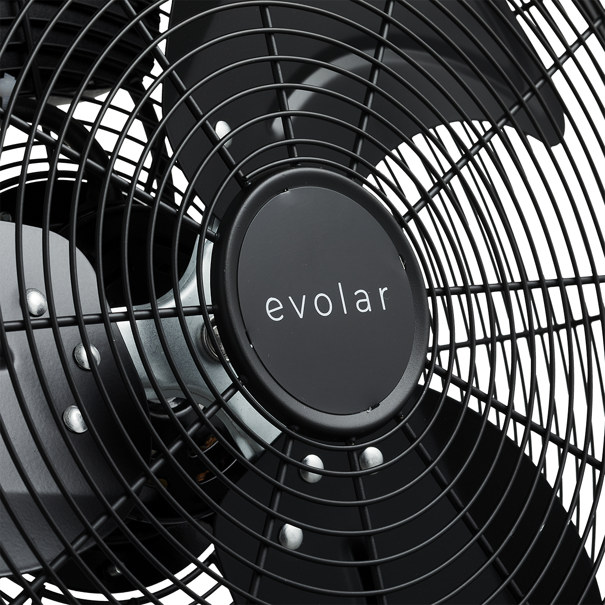 Un primo piano mostra il centro di un ventilatore Evolar nero, evidenziando il marchio e il design circolare in filo metallico.