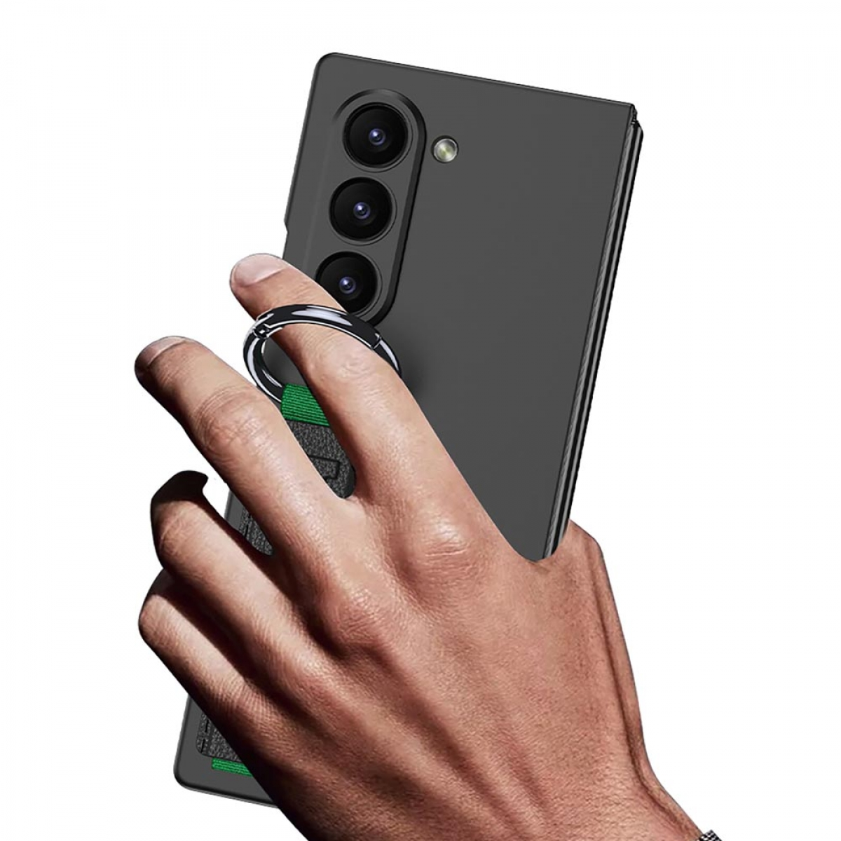Hand hält ein schwarzes Telefon mit grünem Ringhalter. Das Telefon ist gefaltet und hat Kameralinsen.