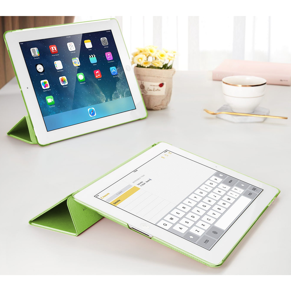 Ein Tablet in einer grünen Hülle zeigt einen Kalender, während ein anderes eine Tastatur anzeigt, beide auf einem Tisch.