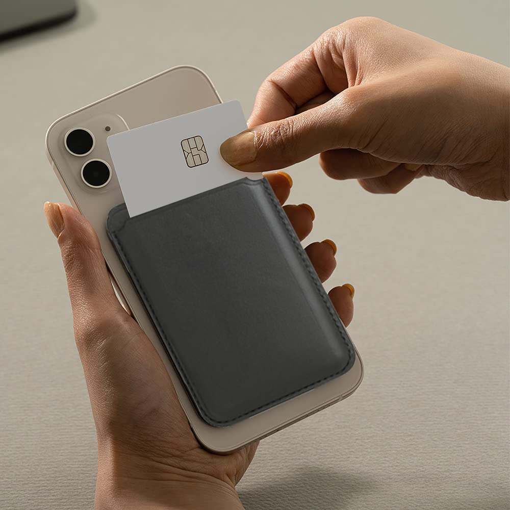 Das Bild zeigt eine Hand, die eine Karte in eine graue Handytasche steckt, die an einem weißen Smartphone befestigt ist.
