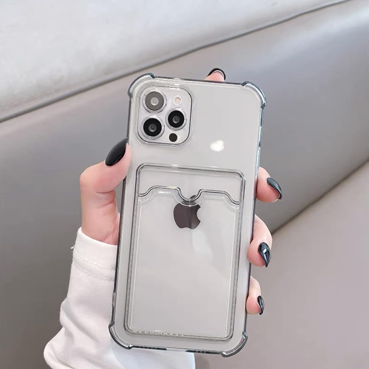 Hand mit durchsichtiger Handyhülle mit sichtbarem Apple-Logo und Kartenhalter auf neutralem Hintergrund.
