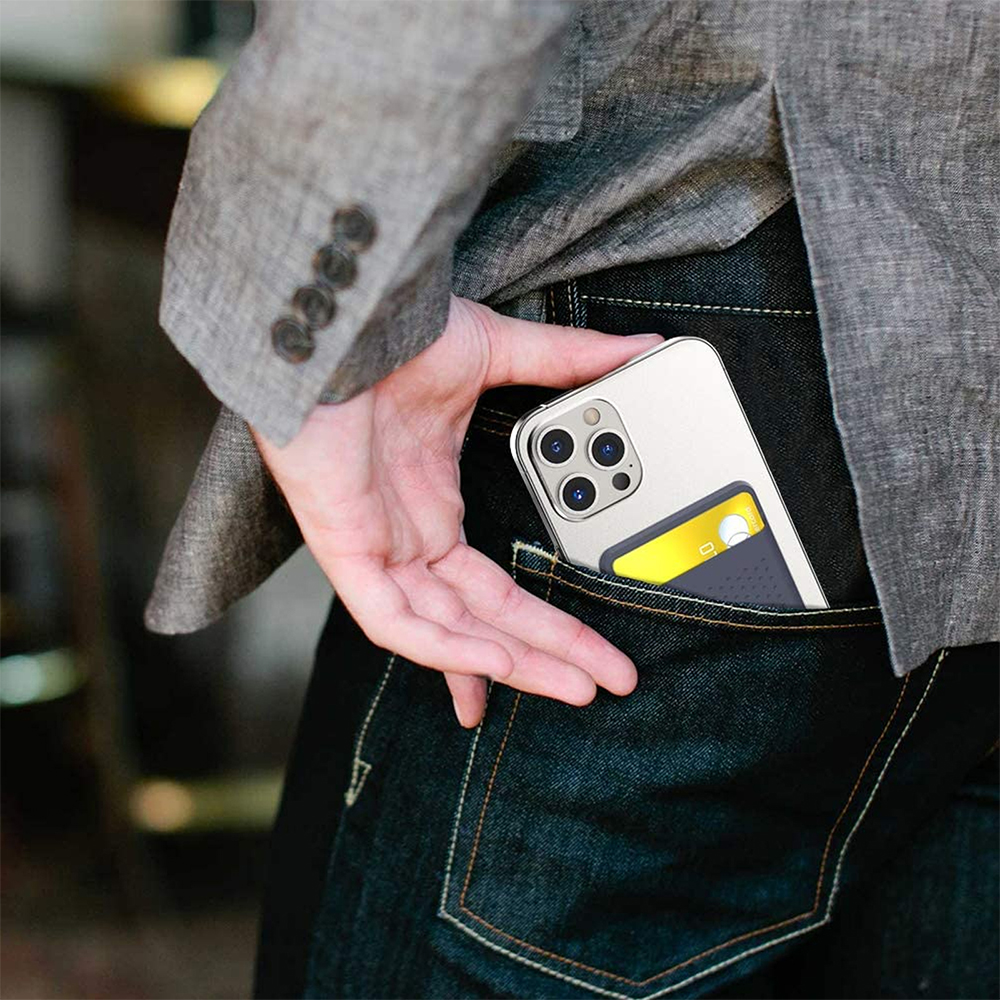 Ein grauer Kartenhalter mit einer Karte wird an einem Telefon in einer Jeanshosentasche gezeigt.
