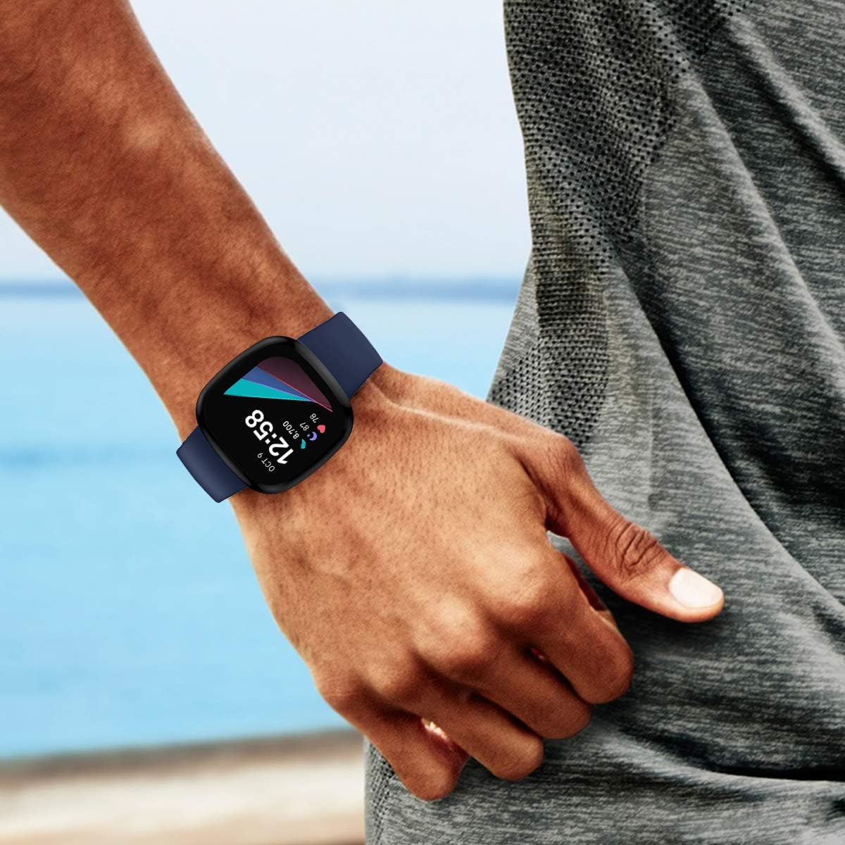 Nahaufnahme einer Smartwatch am Handgelenk einer Person, die ein marineblaues Armband und eine Schutzhülle zeigt.