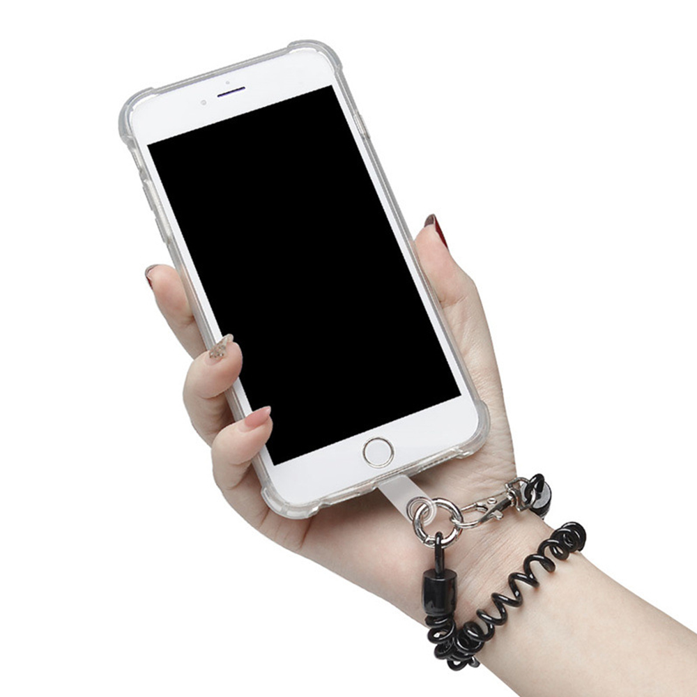 Eine Hand hält ein weißes Telefon mit schwarzem Bildschirm und Handgelenkschlaufe.