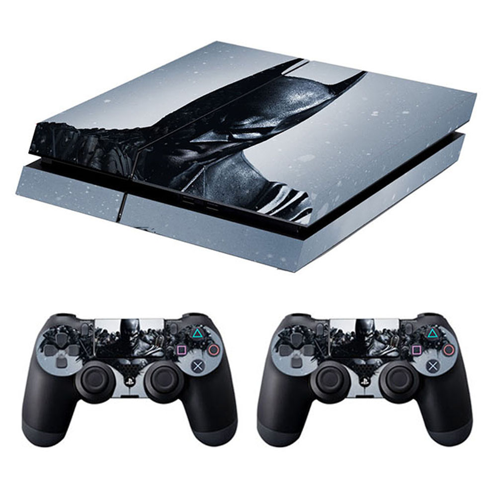 PlayStation 4-Konsole und zwei Controller mit einem Batman-Design vor einem weißen Hintergrund.