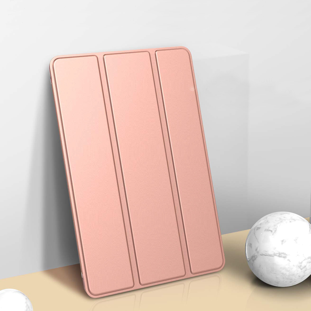 Eine roségoldene Tablet-Hülle mit drei Abschnitten steht auf einer beigen Oberfläche.