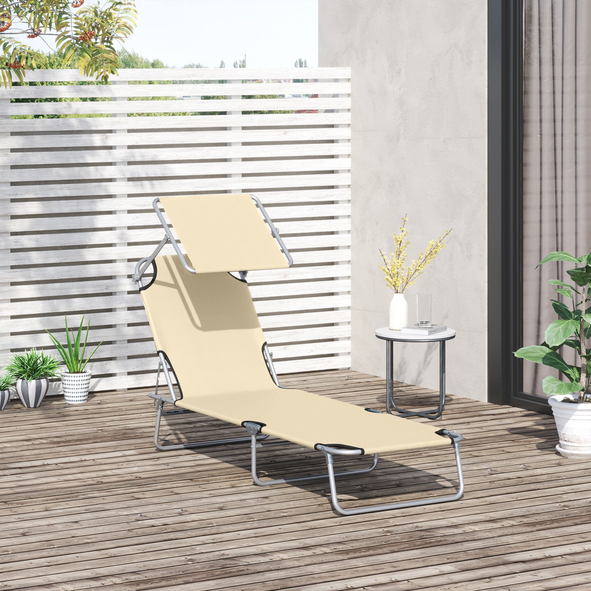 Sedia a sdraio beige con struttura bianca e baldacchino su una terrazza in legno, piante e recinzione bianca, creando una scena rilassante.