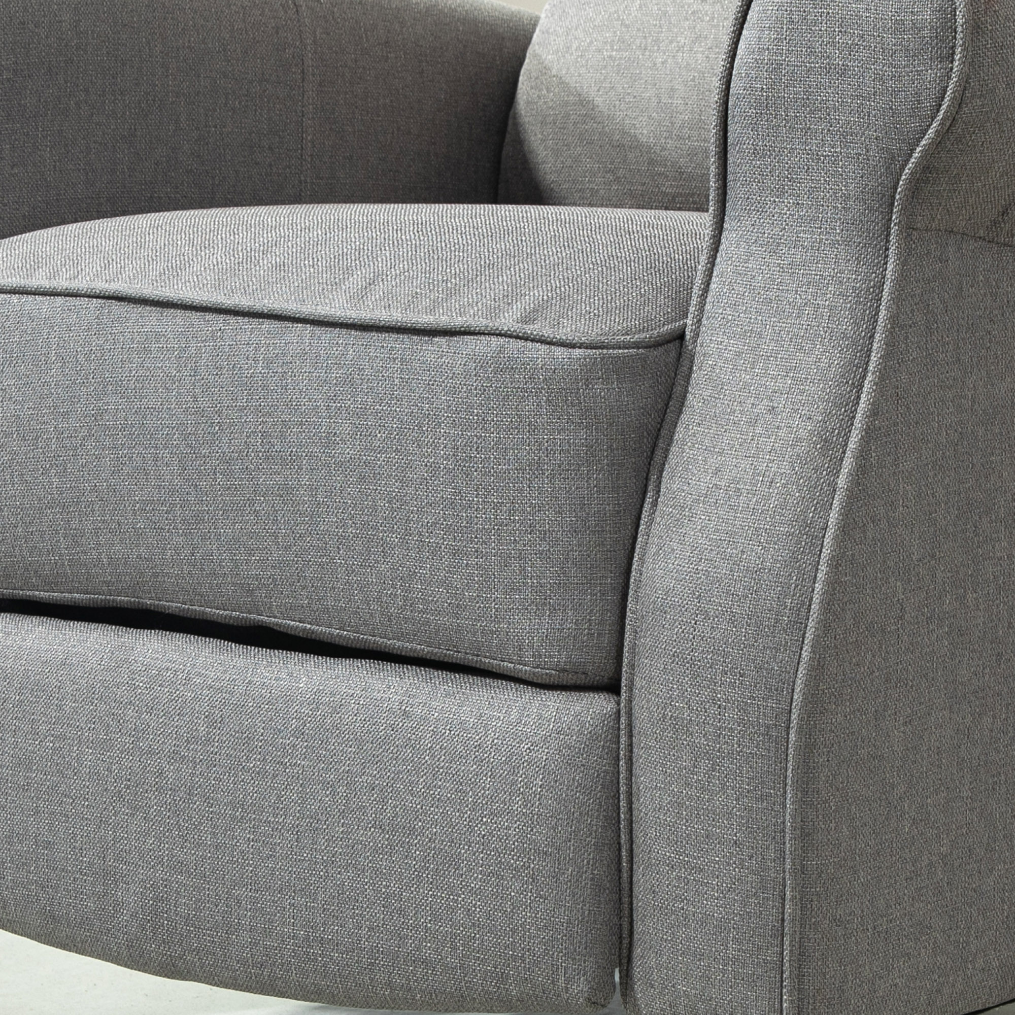Primer plano de la tela gris del reposabrazos del sillón. Se ven los detalles de la costura.