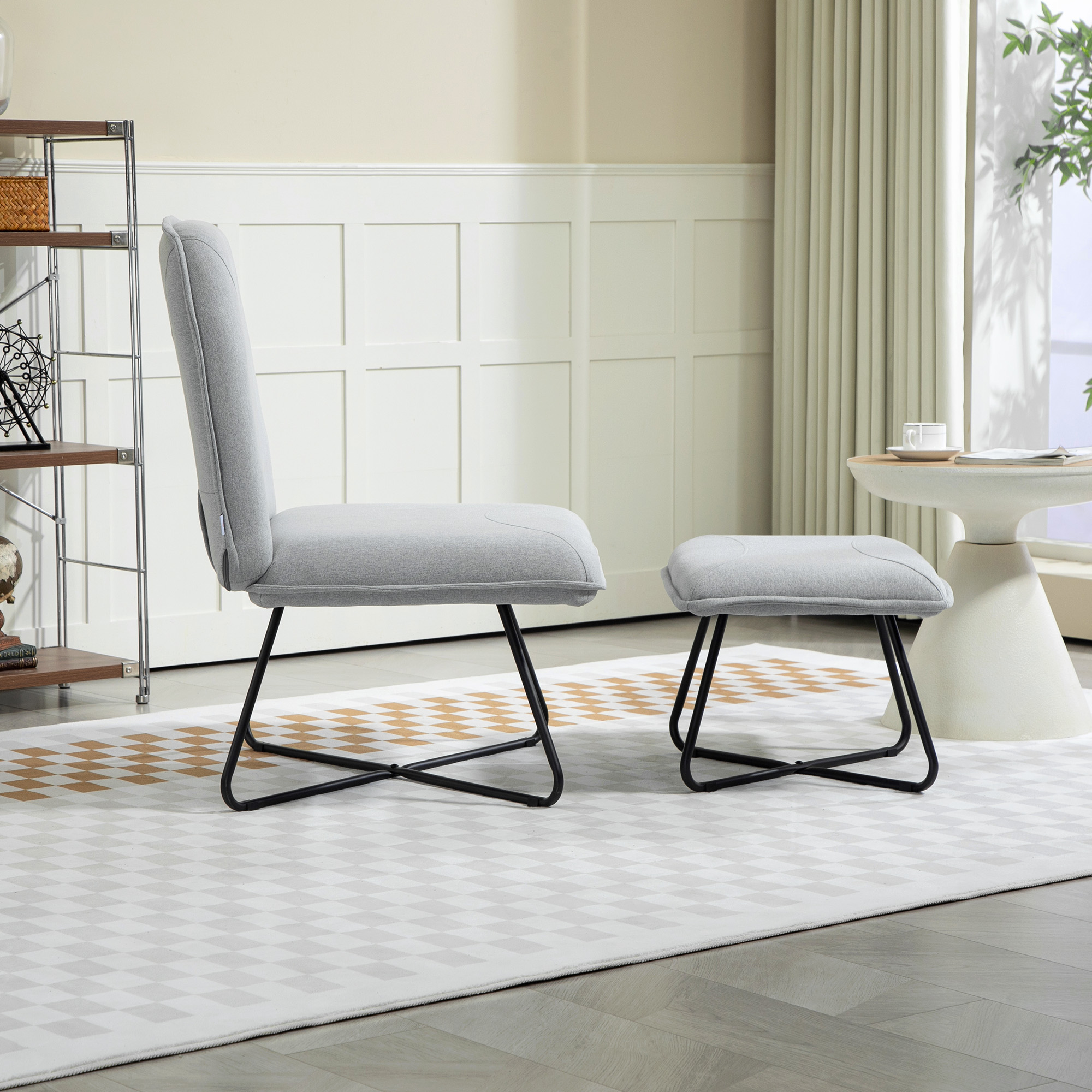 Silla y otomana grises con patas de metal negro sobre una alfombra con estampado de diamantes, en una habitación luminosa y aireada.