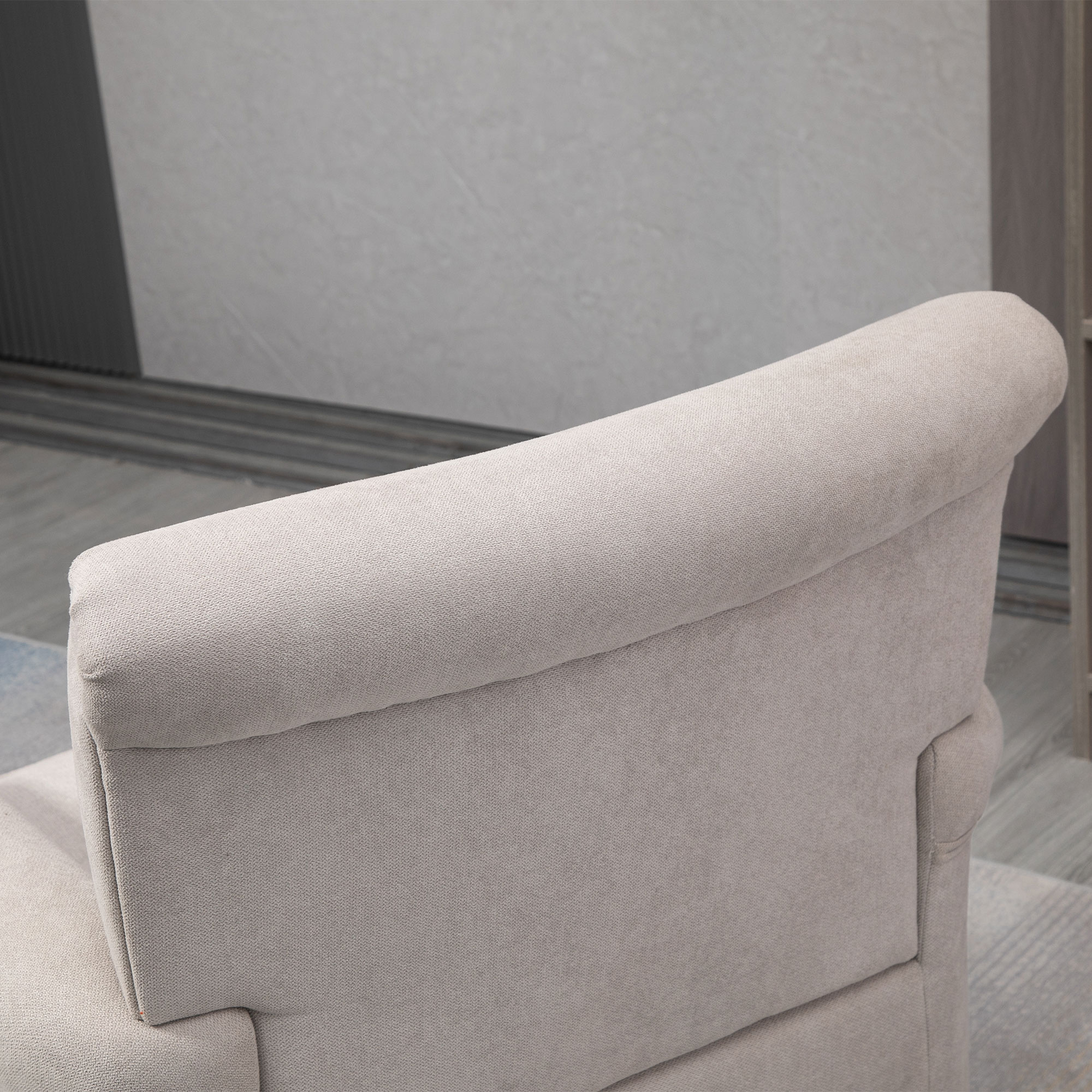 Primer plano de la parte trasera de un sillón beige claro, que revela la forma curva y la textura de la tapicería.