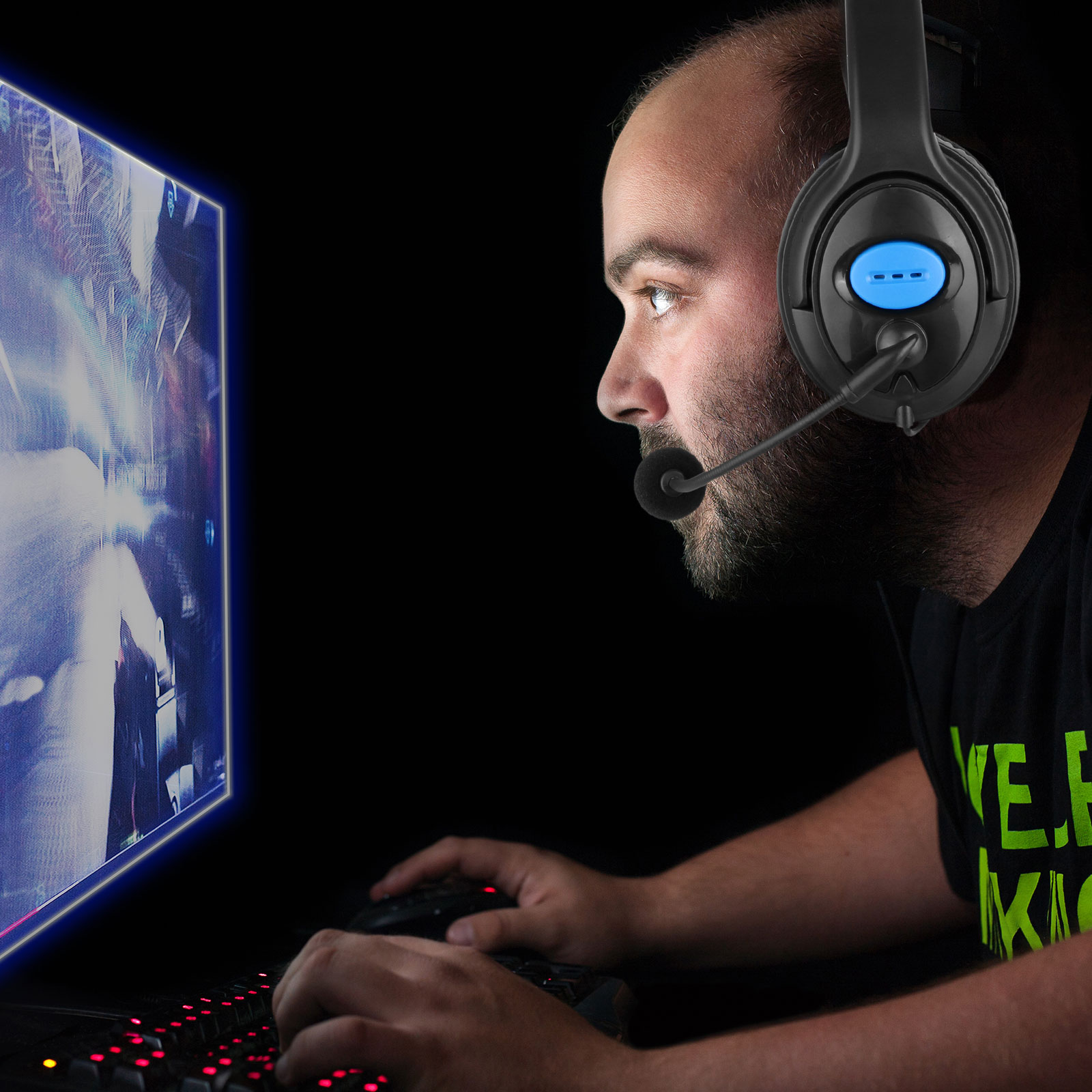 Mann mit Headset beim Spielen. Er schaut auf den Bildschirm, Tastatur davor.
