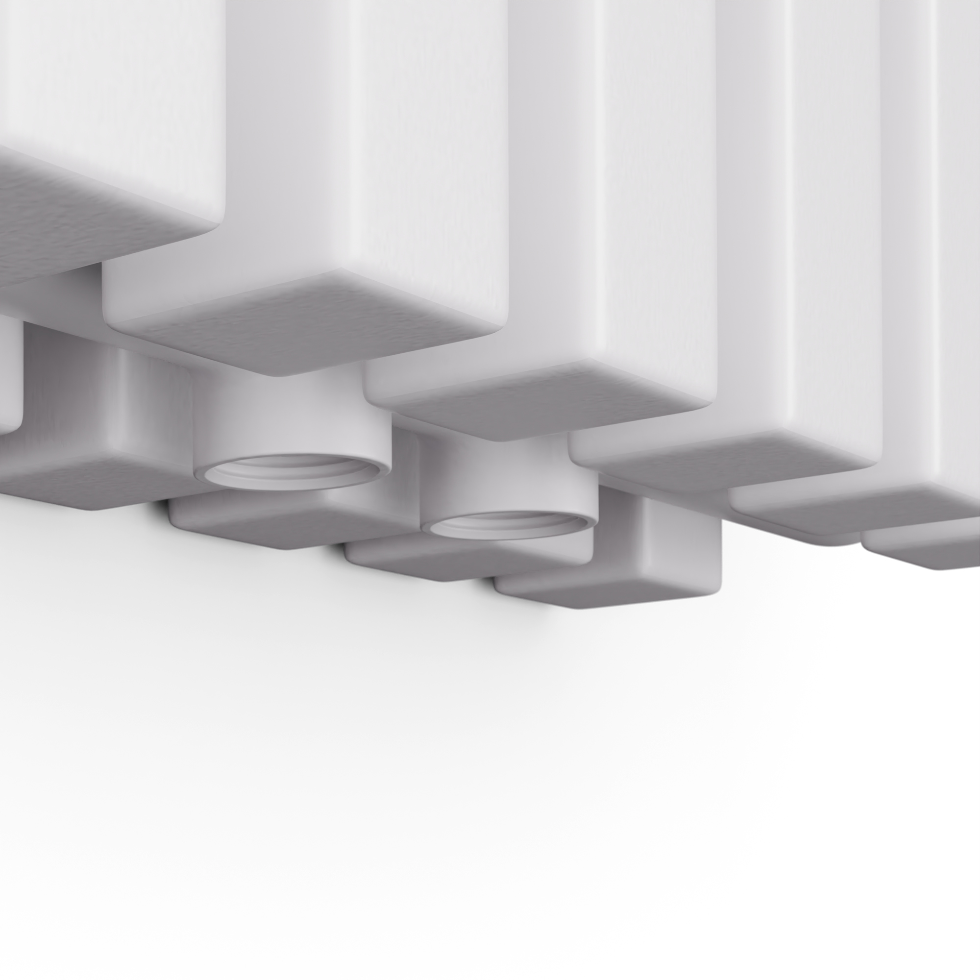 Primo piano della parte superiore di un radiatore bianco con elementi verticali quadrati e fori cilindrici, sfondo bianco.