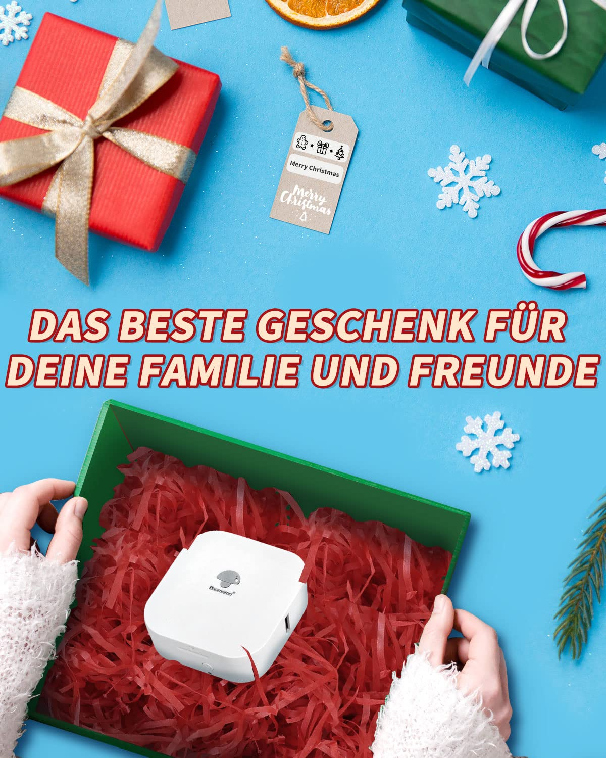 Das Bild zeigt eine Geschenkbox mit einem Etikettendrucker darin. Es gibt Weihnachtsdekorationen darum herum.