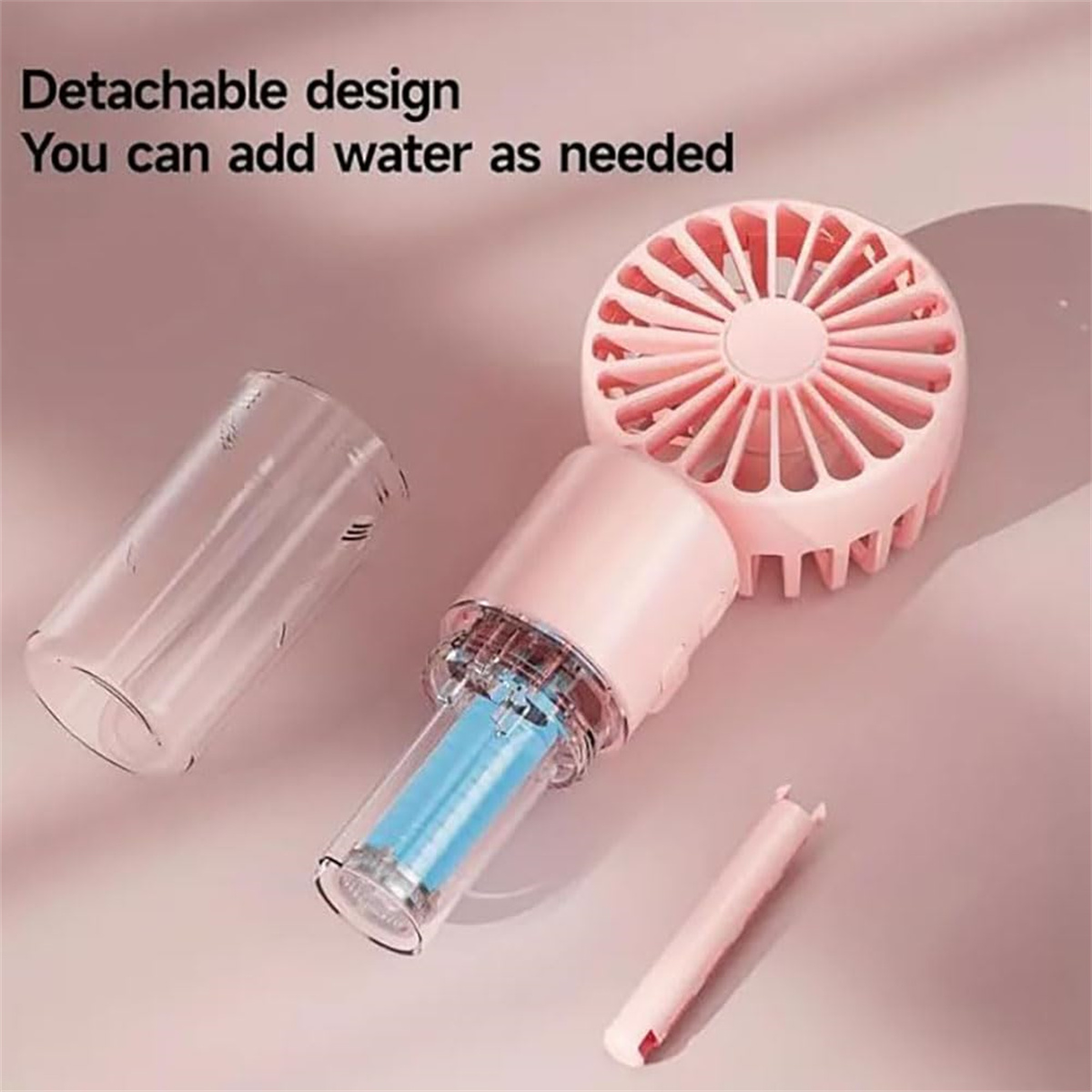 Ein rosa Handventilator ist zerlegt, mit Teilen wie Wasserbehälter und Lüfterflügeln.