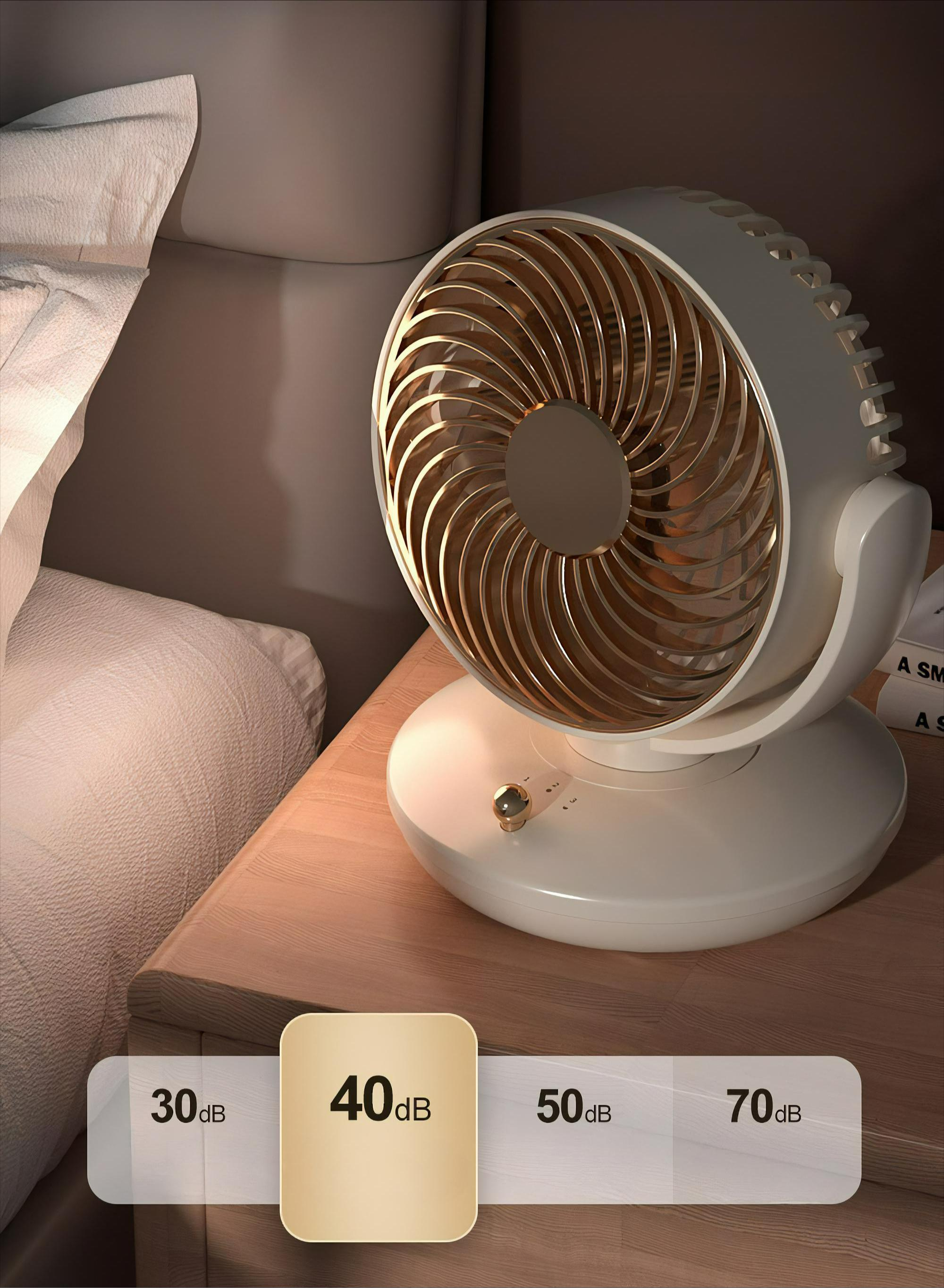 Ein weißer und goldener Ventilator steht auf einem Nachttisch mit Geräuschpegelanzeigen neben einem Bett.