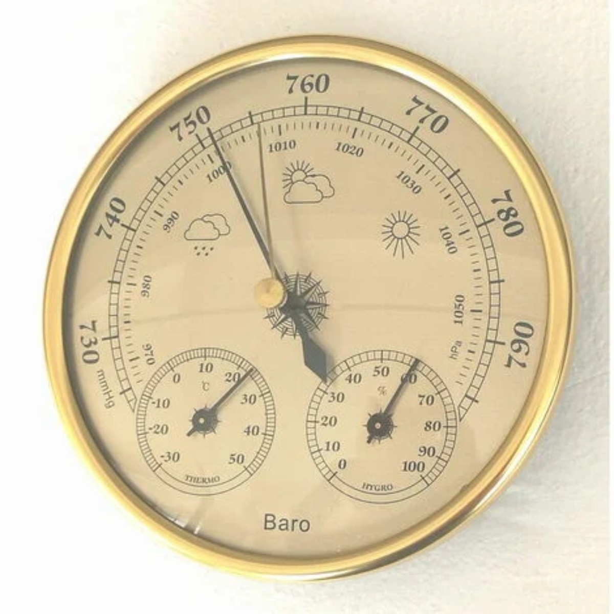 Ein runder, analoger Barometer mit Goldrahmen, der Temperatur-, Feuchtigkeits- und Druckmesswerte anzeigt.