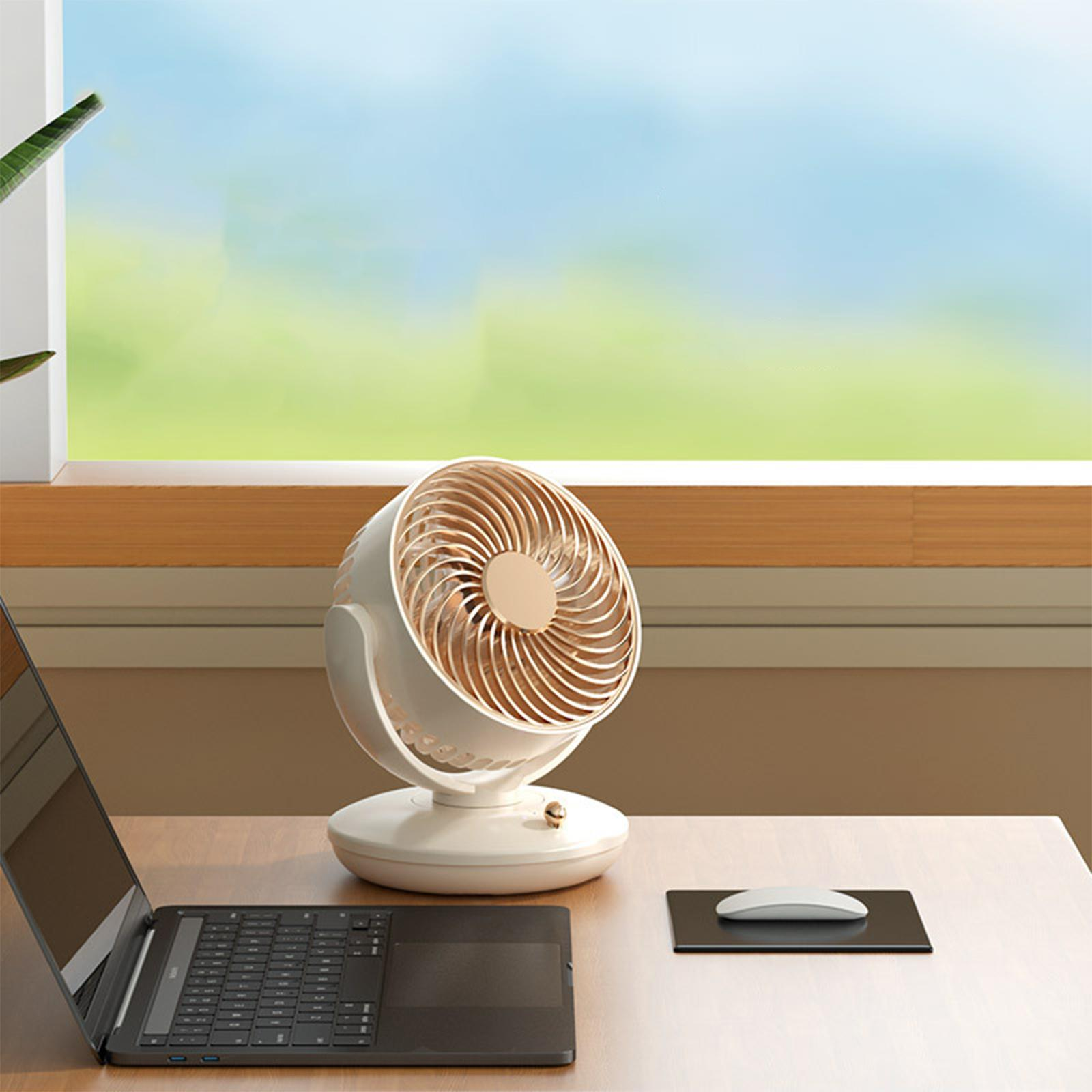 Ein weiß-goldener Ventilator auf einem Holzschreibtisch mit Laptop und Maus. Ein grünes und blaues Fenster ist sichtbar.