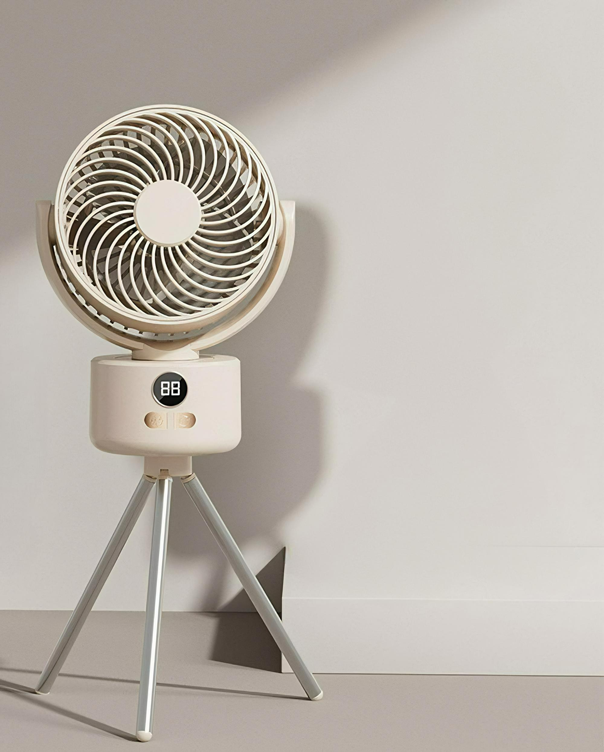Ein weiß-beigefarbener Ventilator auf einem Stativ. Der Ventilator hat eine Digitalanzeige.