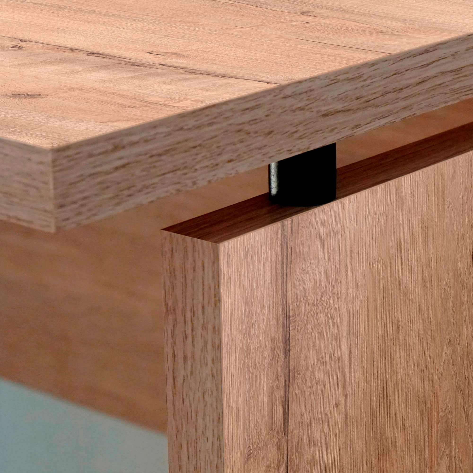 Primer plano de una esquina de escritorio de madera que muestra la unión y los detalles de la veta de la madera. Soporte de metal negro visible.