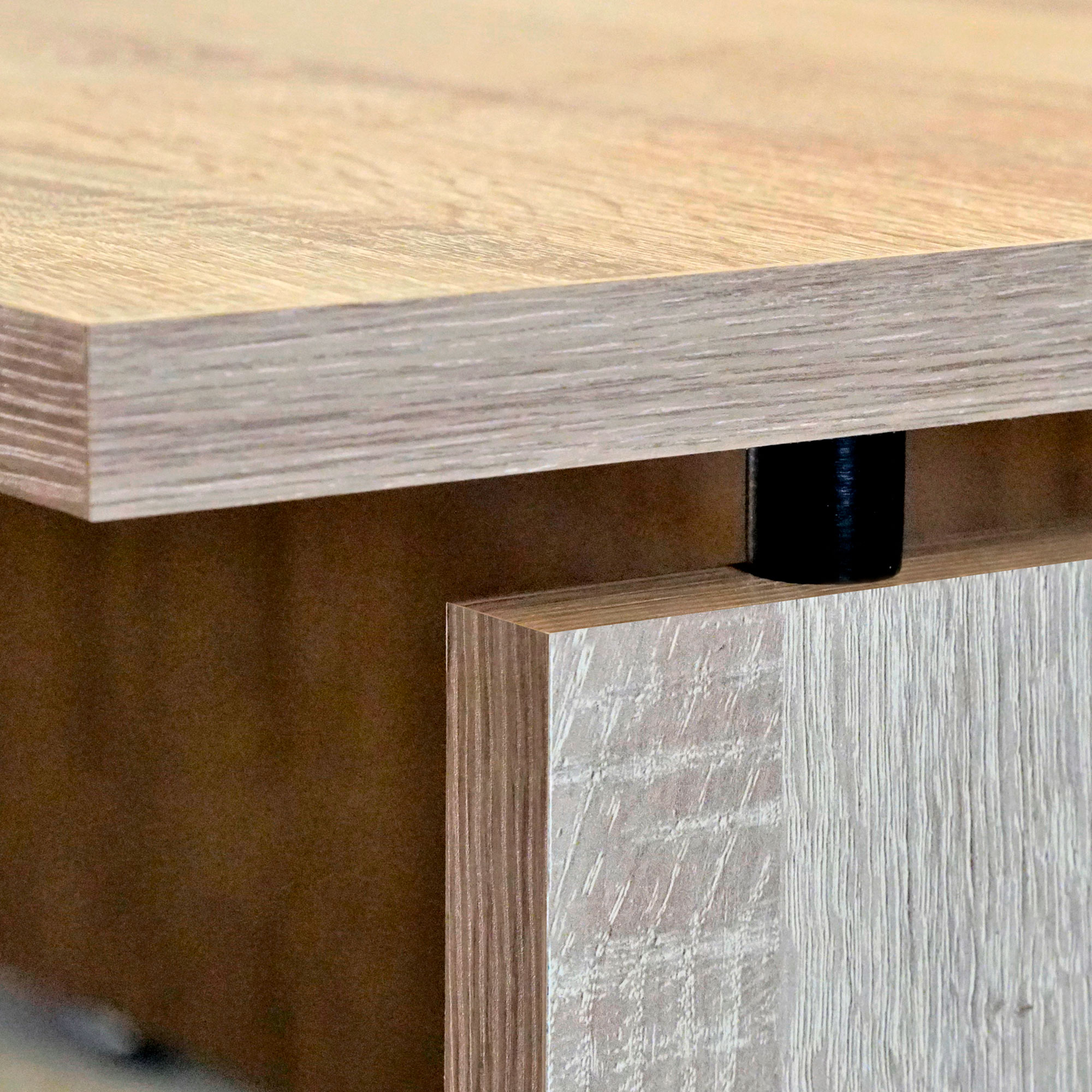 Primer plano de una esquina de escritorio de madera, mostrando la veta y detalles.