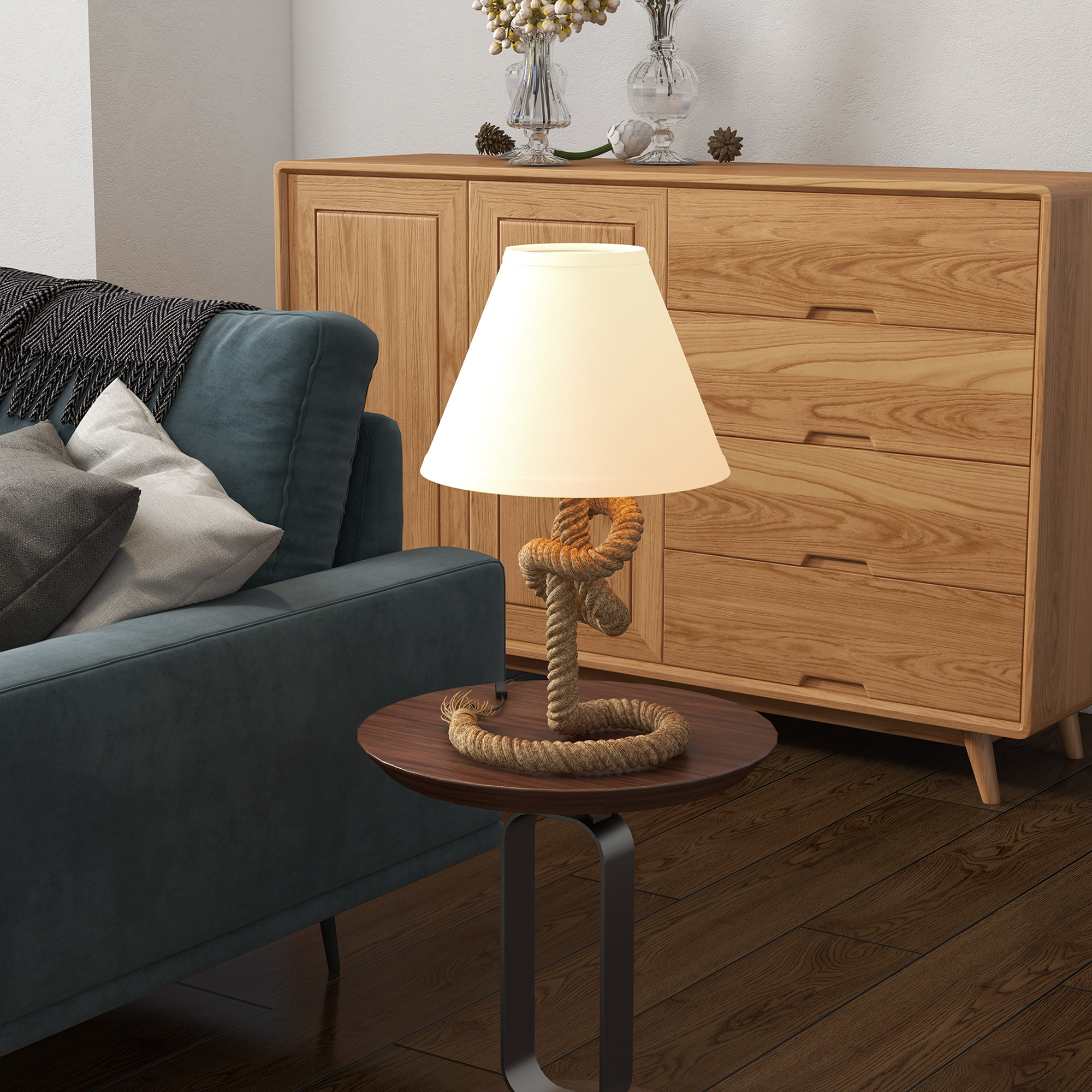 Lámpara de mesa con base de cuerda y pantalla crema, sobre una mesa redonda de madera.