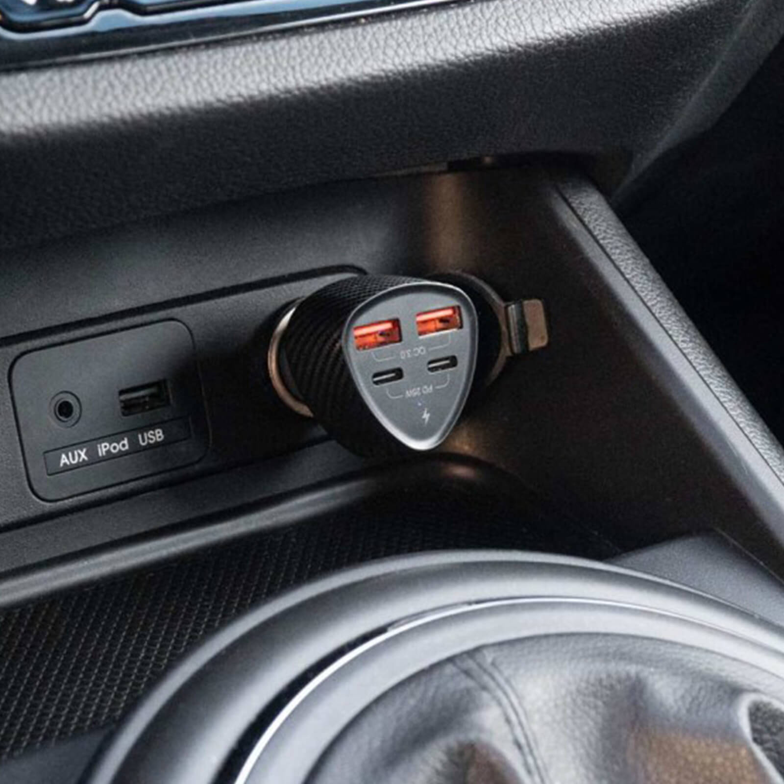 Un caricatore per auto inserito nella porta AUX/iPod/USB dell'auto. Ha due porte.