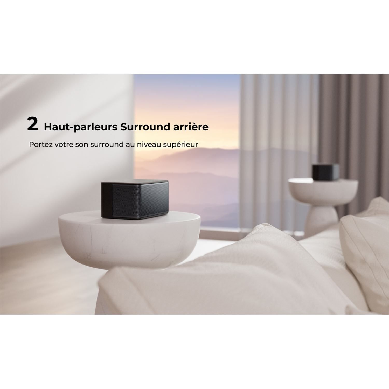 Een zwarte speaker op een witte tafel in een woonkamer. Tekst: '2 Haut-parleurs Surround arrière'.
