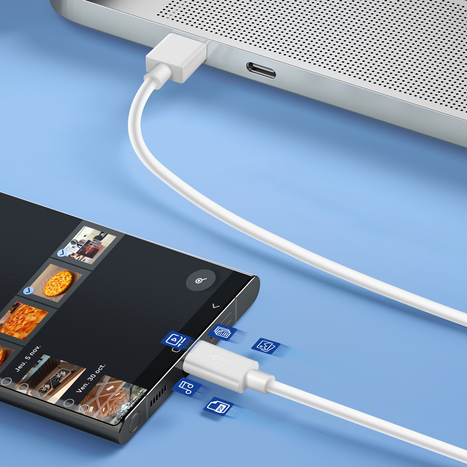 Un cavo bianco collega un telefono che visualizza immagini a un laptop su una superficie blu.