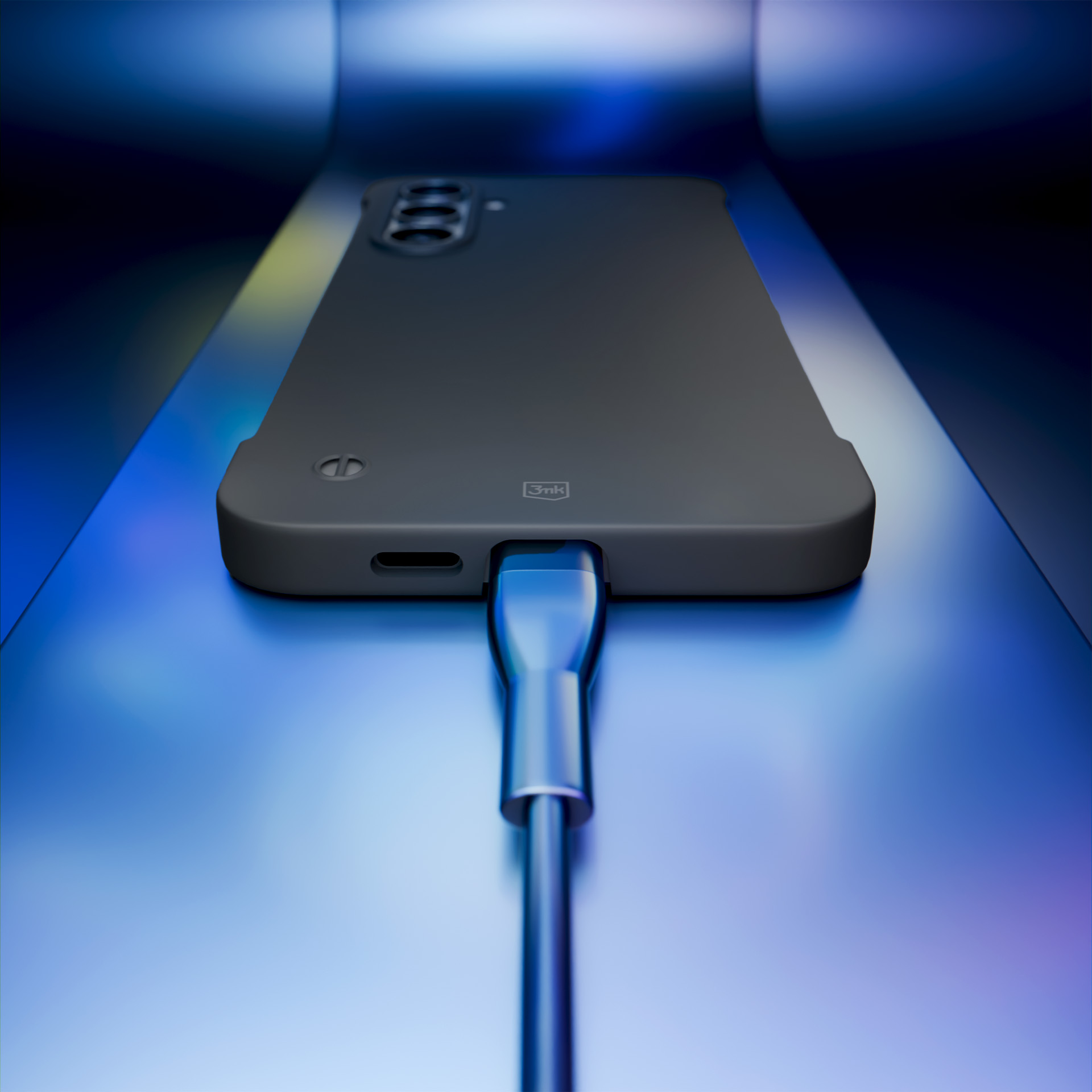 Szare etui na telefon jest ładowane za pomocą kabla USB-C na odblaskowej niebieskiej powierzchni, co podkreśla jego wygląd.