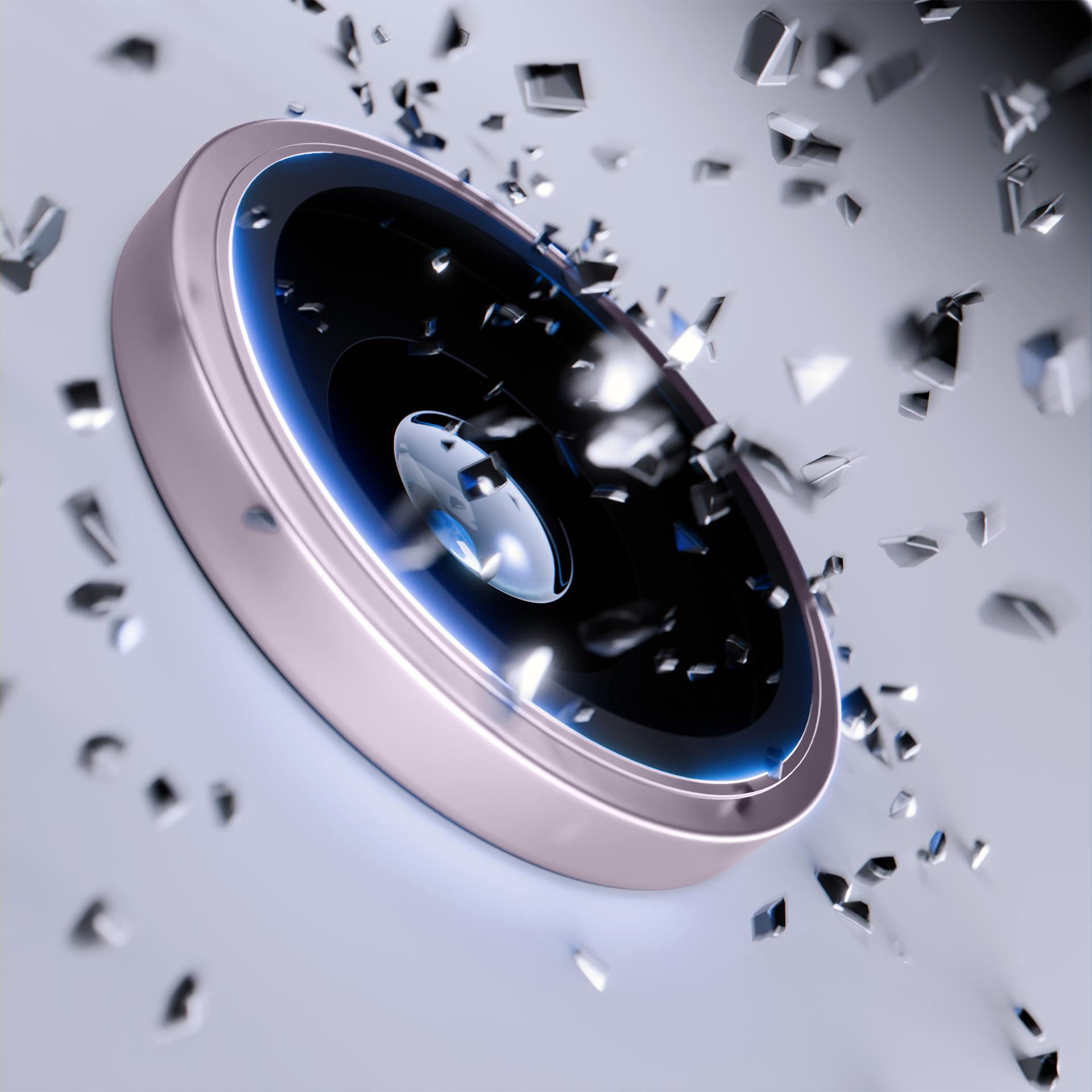 Ukośne zbliżenie obiektywu telefonu z latającymi wokół niego odłamkami.